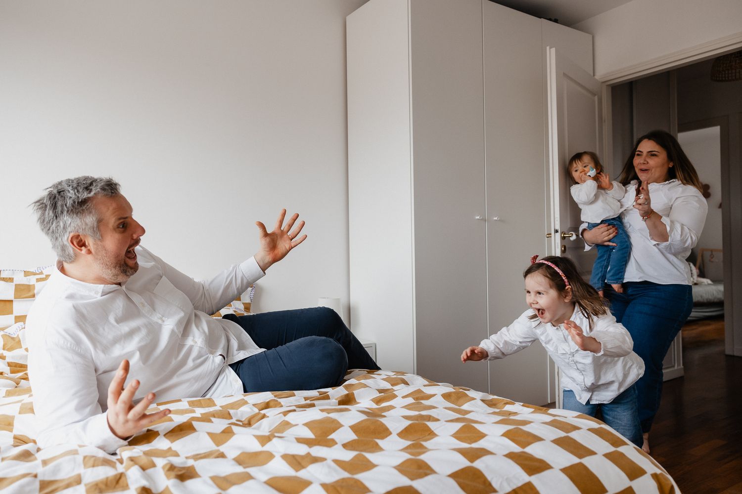 Famille de 4 jouant a cache cache, scene de vie pleine d'energie capturee par une photographe de famille a domicile a Lille