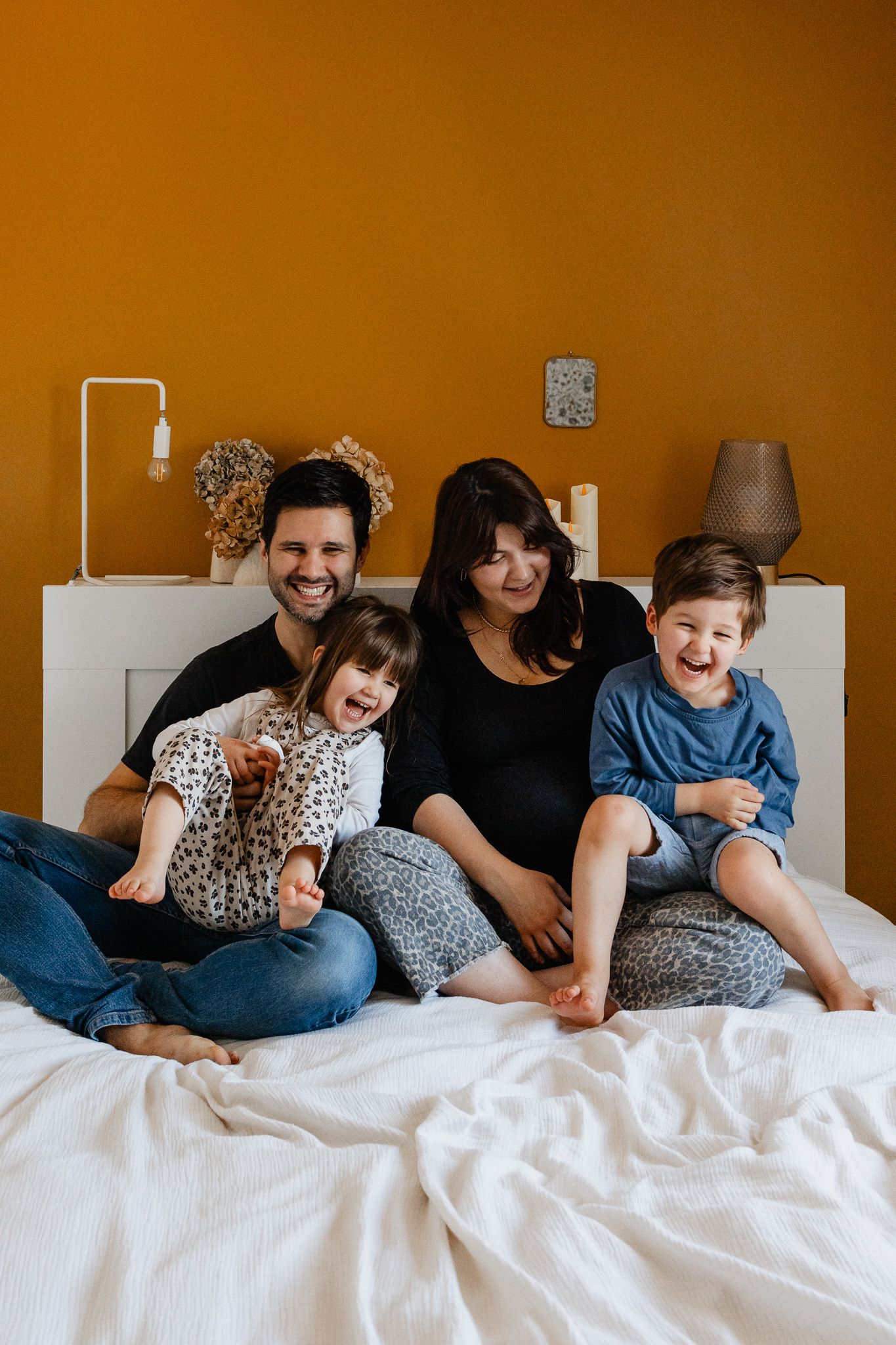 seance photo lifestyle a domicile a La Madeleine pres de Lille, une famille joue et fait des calins sur le lit dans la chambre des parents