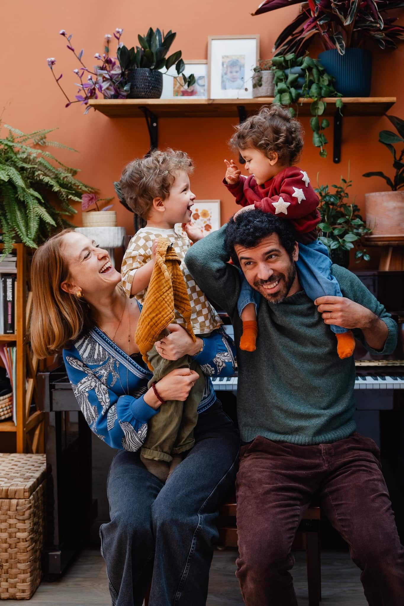 Famille joyeuse jouant ensemble pour un portrait vivant et naturel en seance photo lifestyle a domicile a Croix pres de Lille
