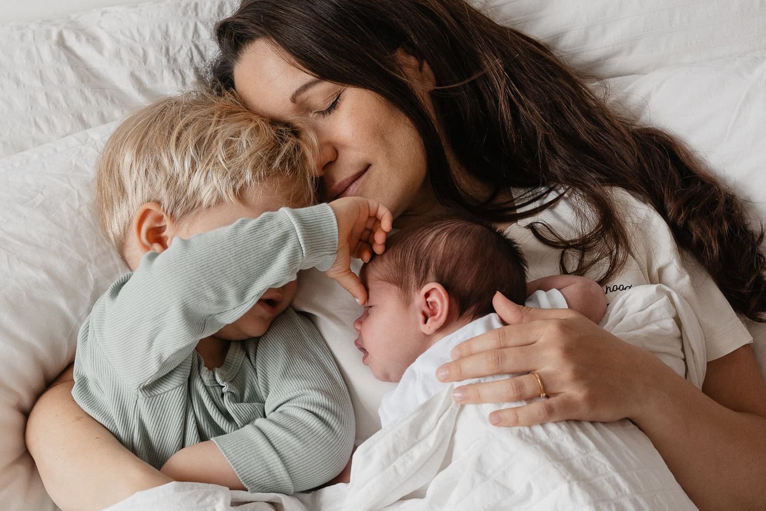 Photo d'un moment de tendresse entre une mere et ses enfants capturee par une photographe de famille lifestyle a domicile pres de Lille