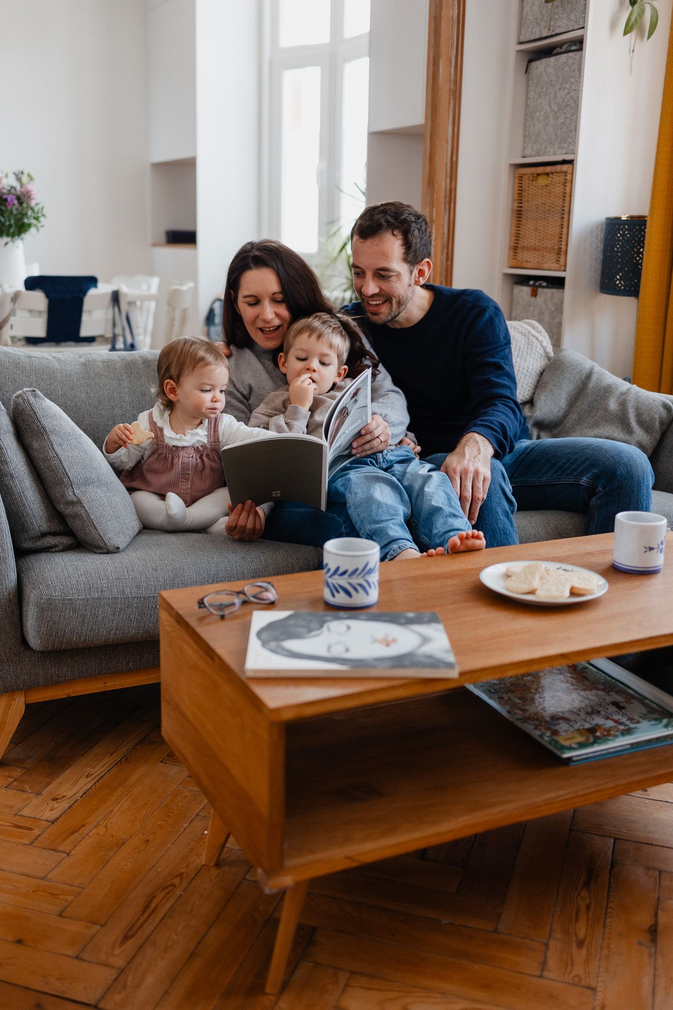 Famille sur le canape feuillete le livre de photos qualite premium cree a partir des images de leur seance photo de famille a Lille
