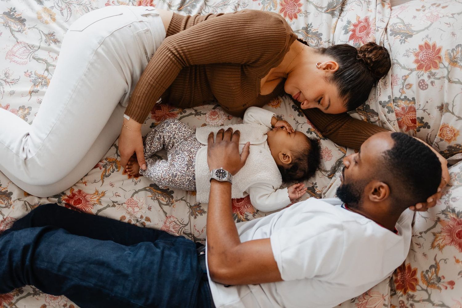 Seance photo famille lifestyle Lille, calins dans le lit des parents, ambiance douce et authentique, famille metisse pleine de tendresse