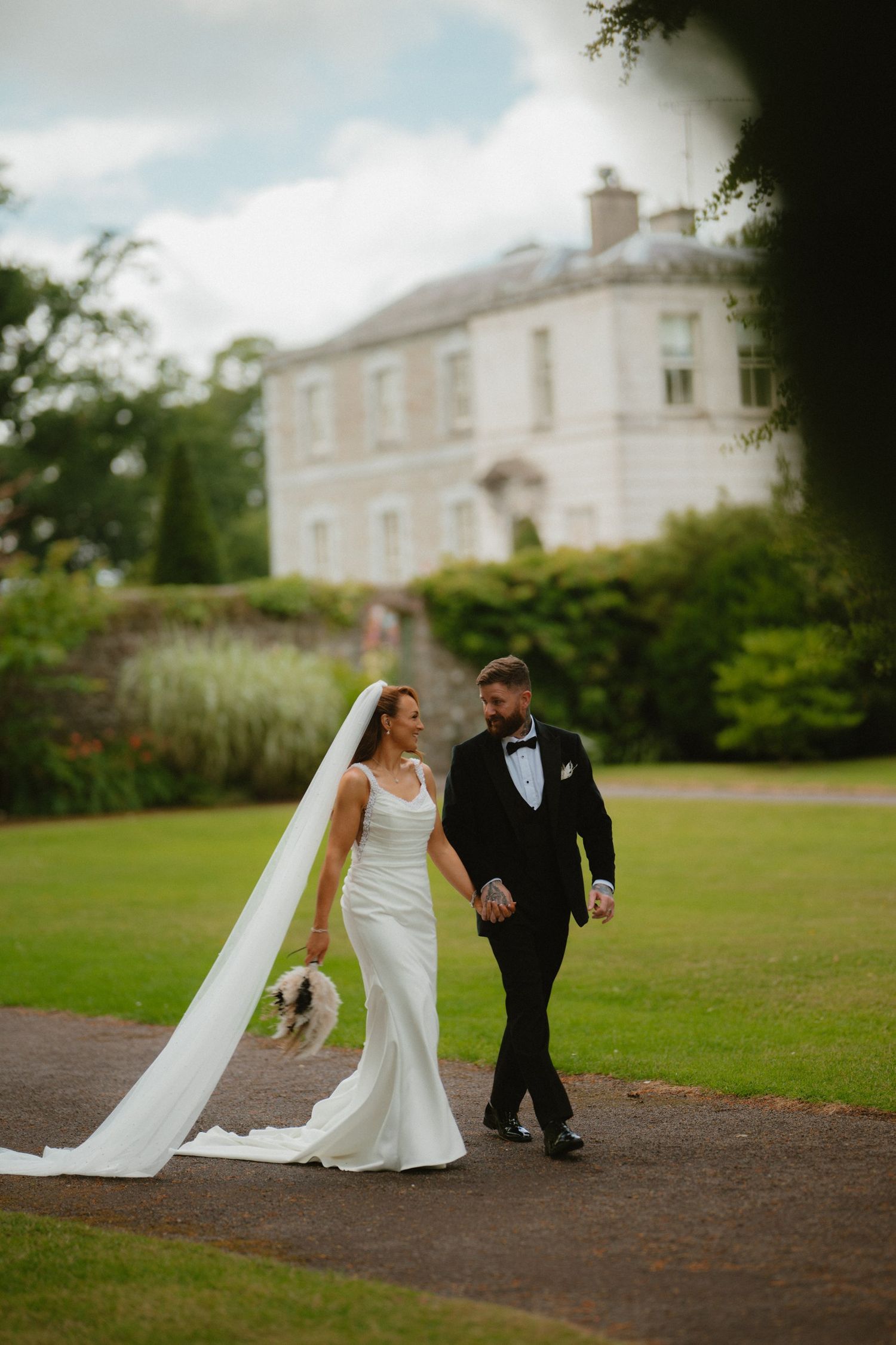 Bride and groom walking together outside Tankardstown House.