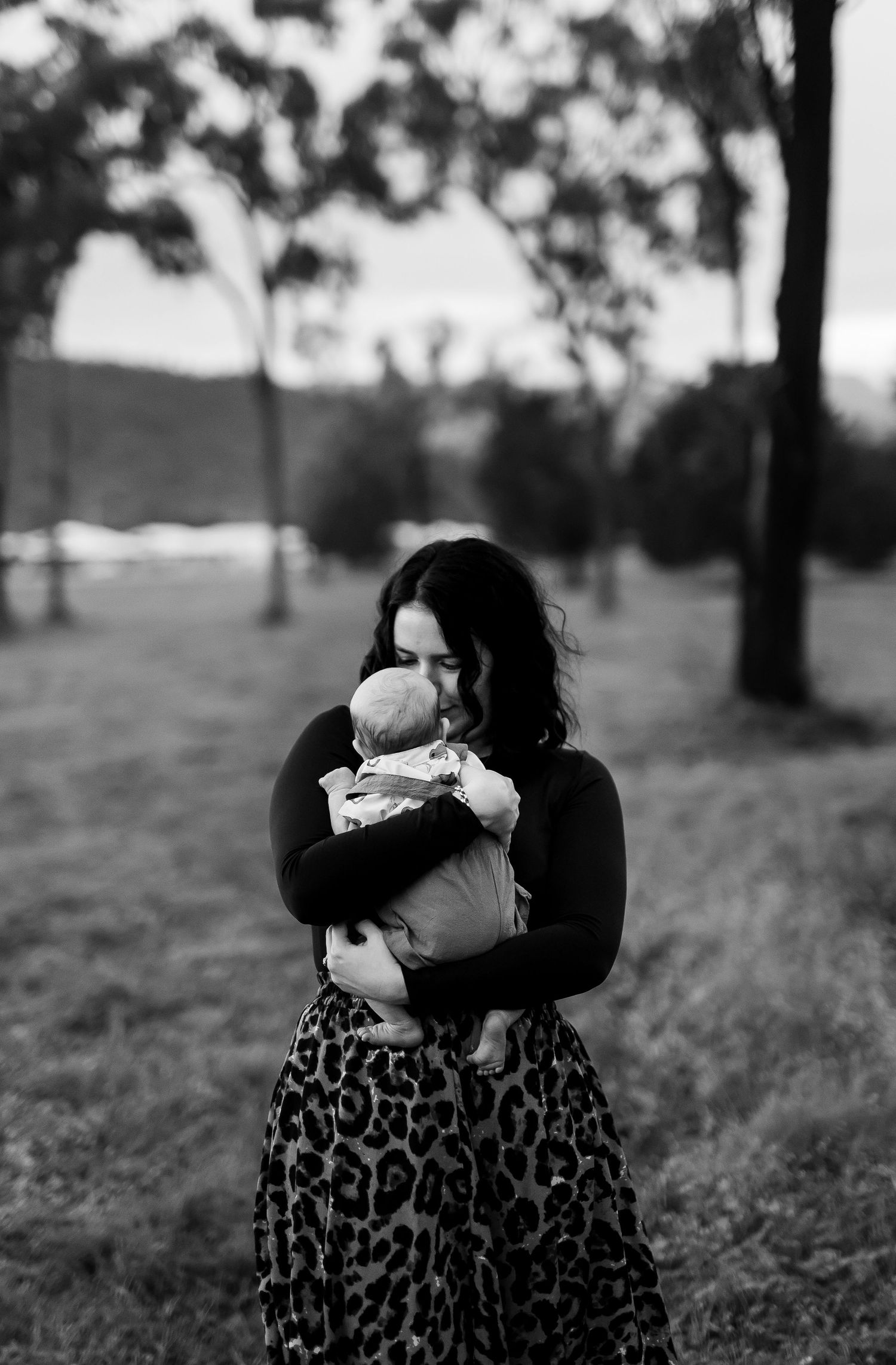 Black and white outdoor portrait showing tender moments in a natural setting.
