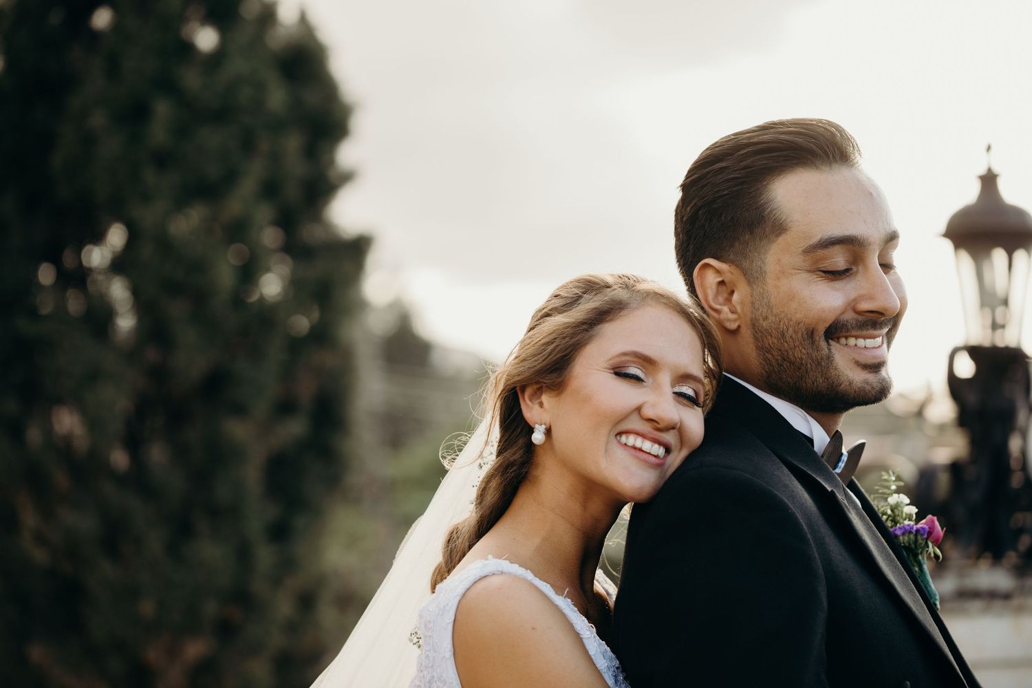 A romantic wedding portrait of a couple sharing an intimate moment outdoors.