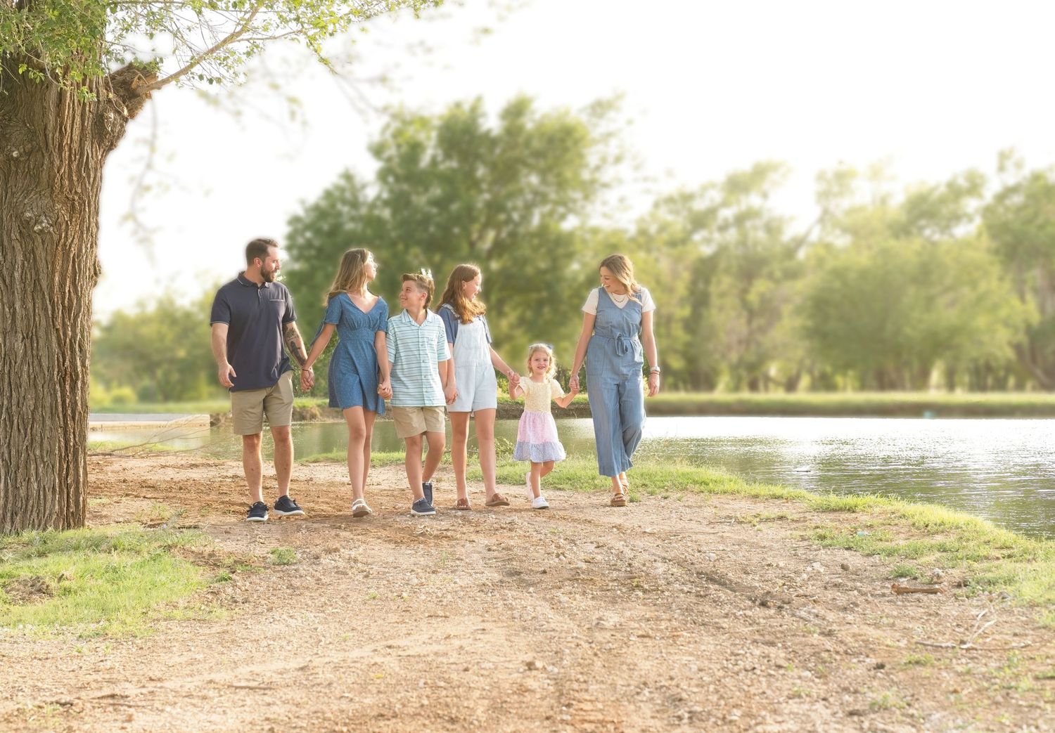 A group walking together on a scenic trail near a lake during golden hour.