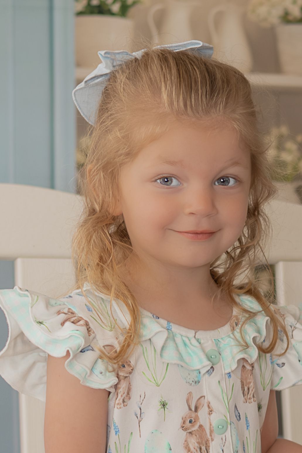 A young child wearing a floral dress with ruffled sleeves poses in a sequence of close-up portrait shots.