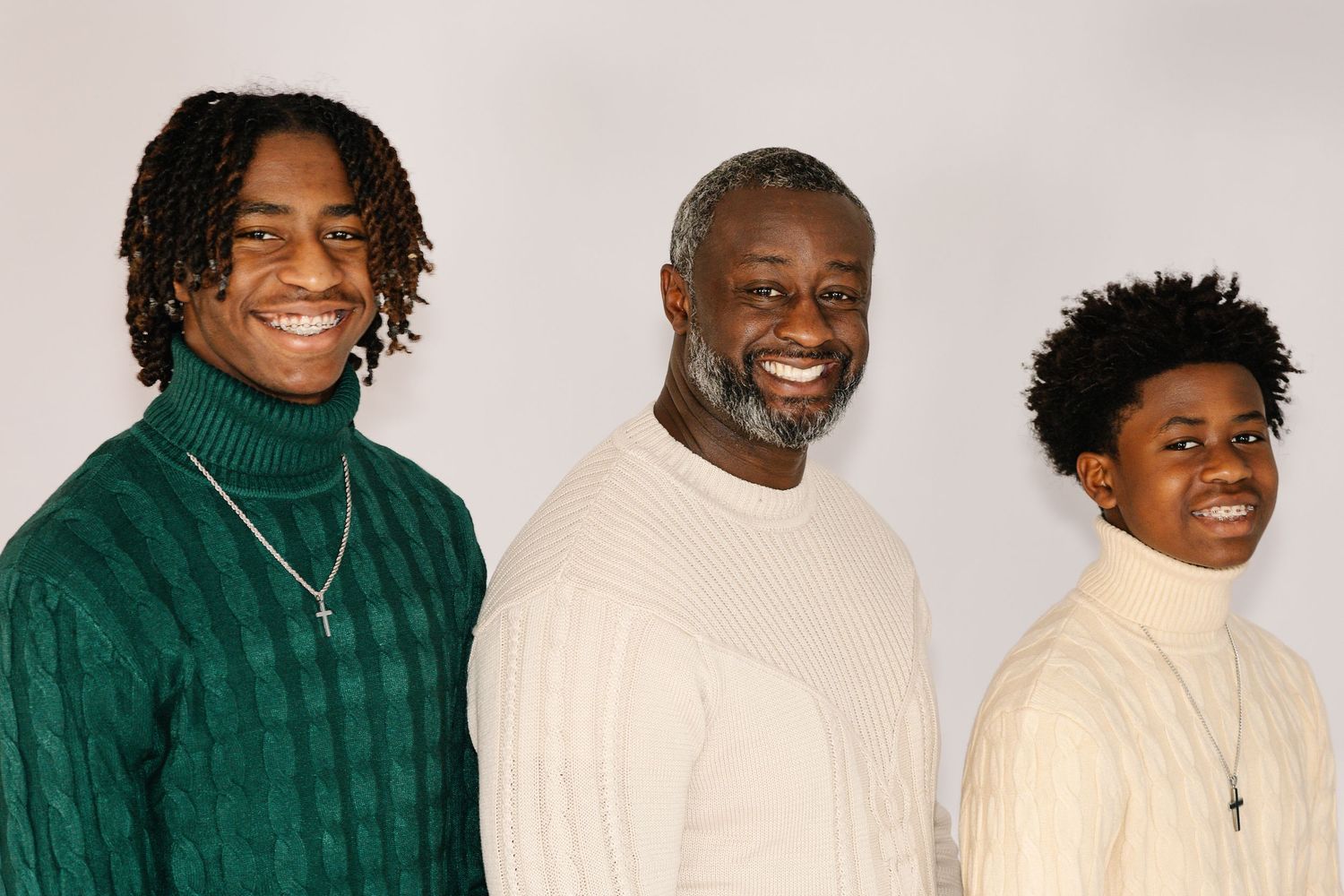 Group photo with family members wearing matching green and cream colored sweaters.