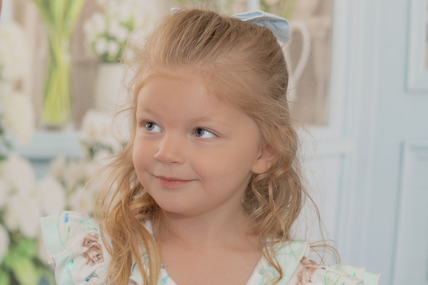 A series of three photos shows a young child in a white dress with floral details in a bright interior setting.