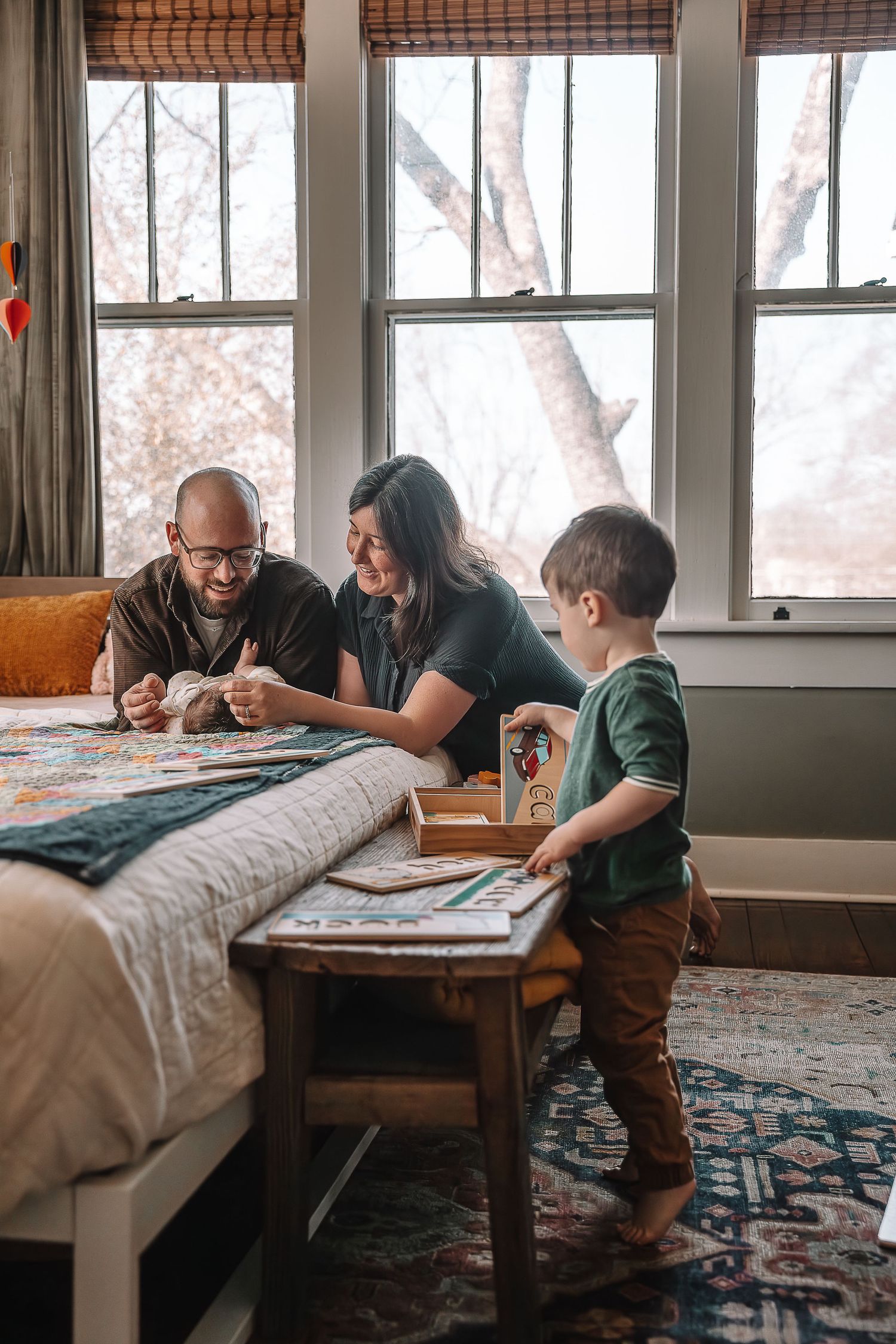 Family playing board game together at coffee table with colorful rug in cozy living room setting.