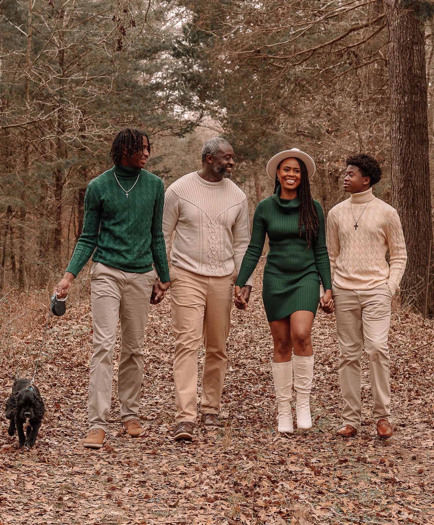 Family walking together through wooded area wearing coordinated outfits.