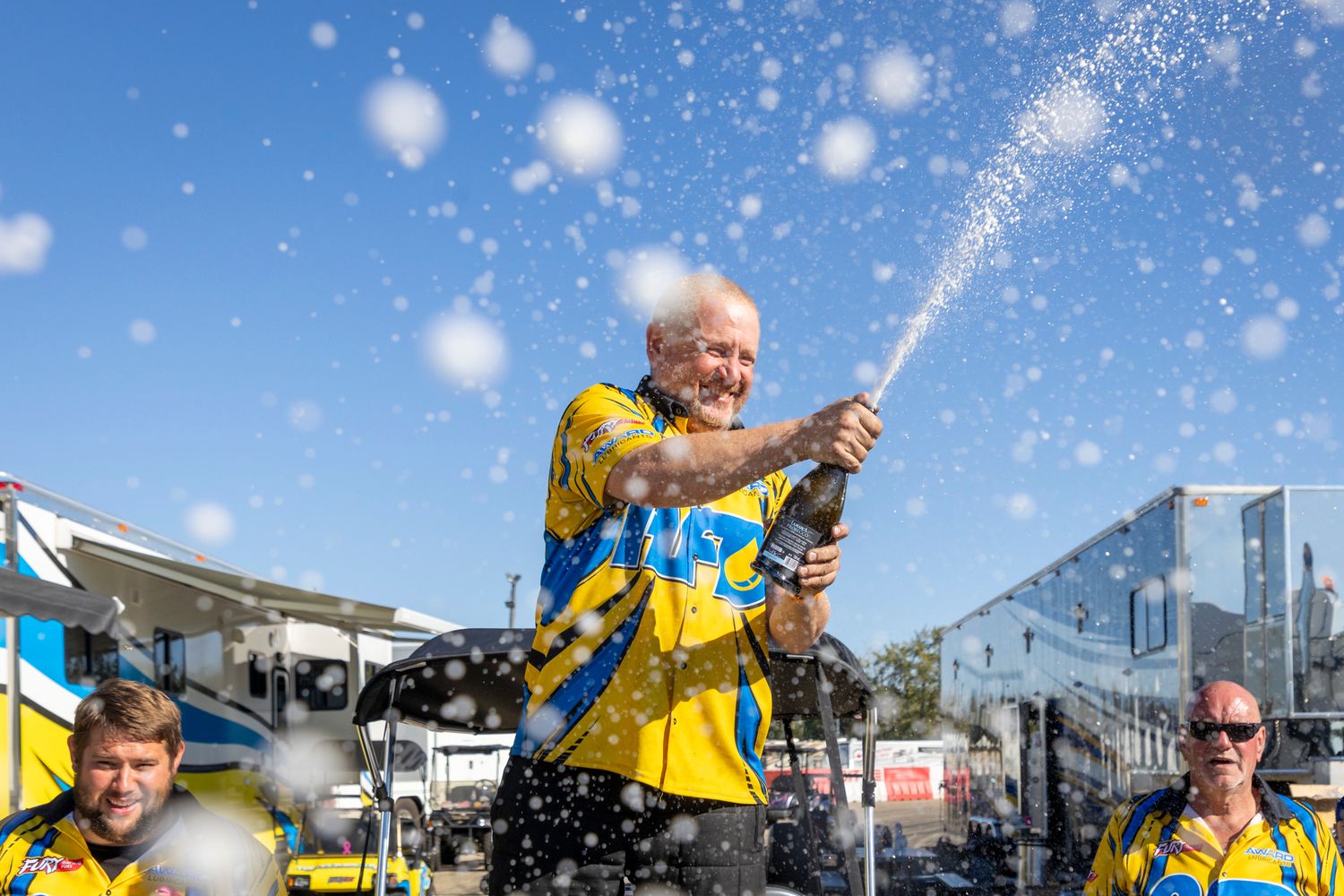 Winning team pops champagne in celebration at Rad Torque Raceway during TOPE weekend festivities.