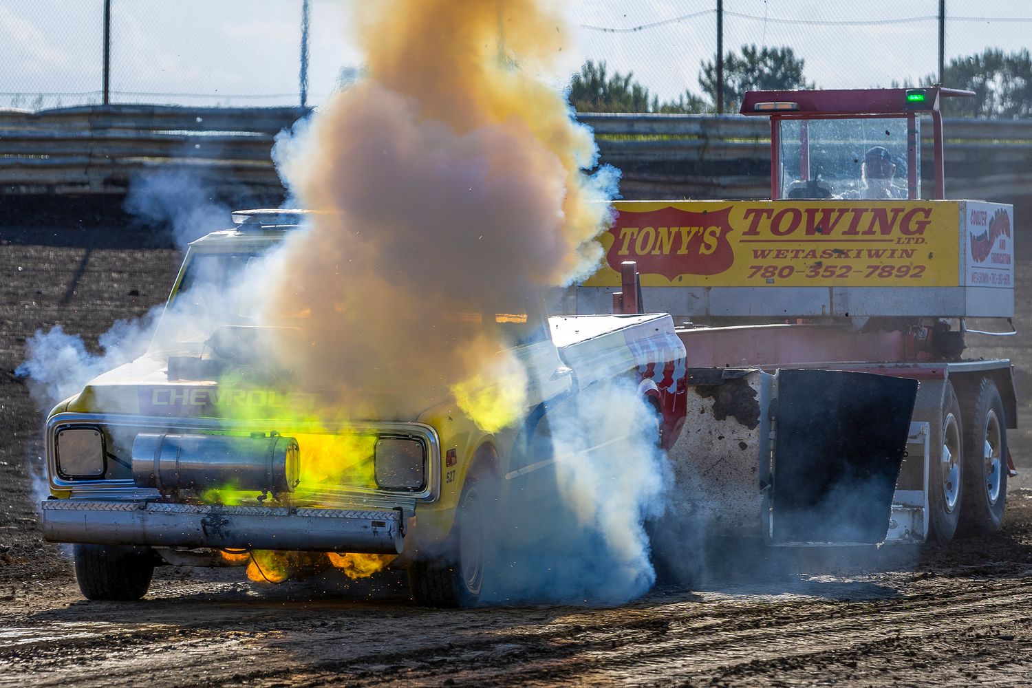 Truck erupts in colourful smoke and fire during a wild tractor pull at Rad Torque Raceway’s Diesel Days event.