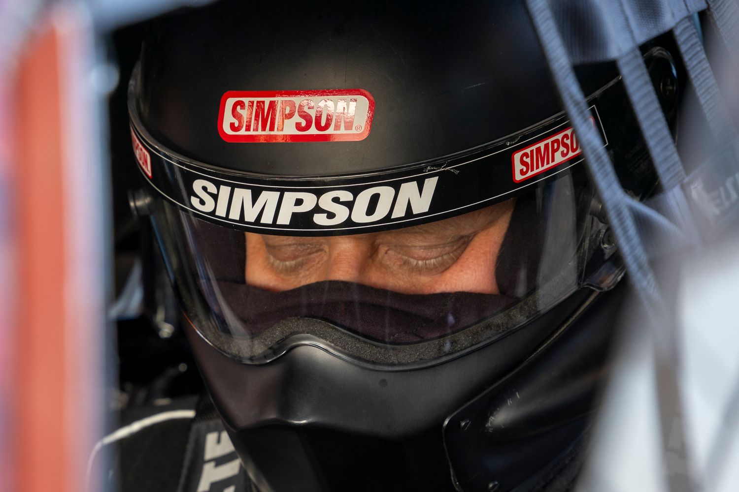 Close-up of drag racer in Simpson helmet, fully focused inside the cockpit during Rocky Mountain Nationals.