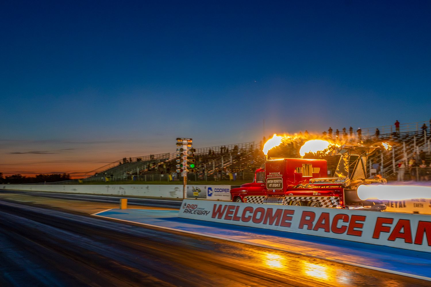 Flame-throwing jet dragster streaks down the strip at sunset during the Rocky Mountain Nationals at Rad Torque.