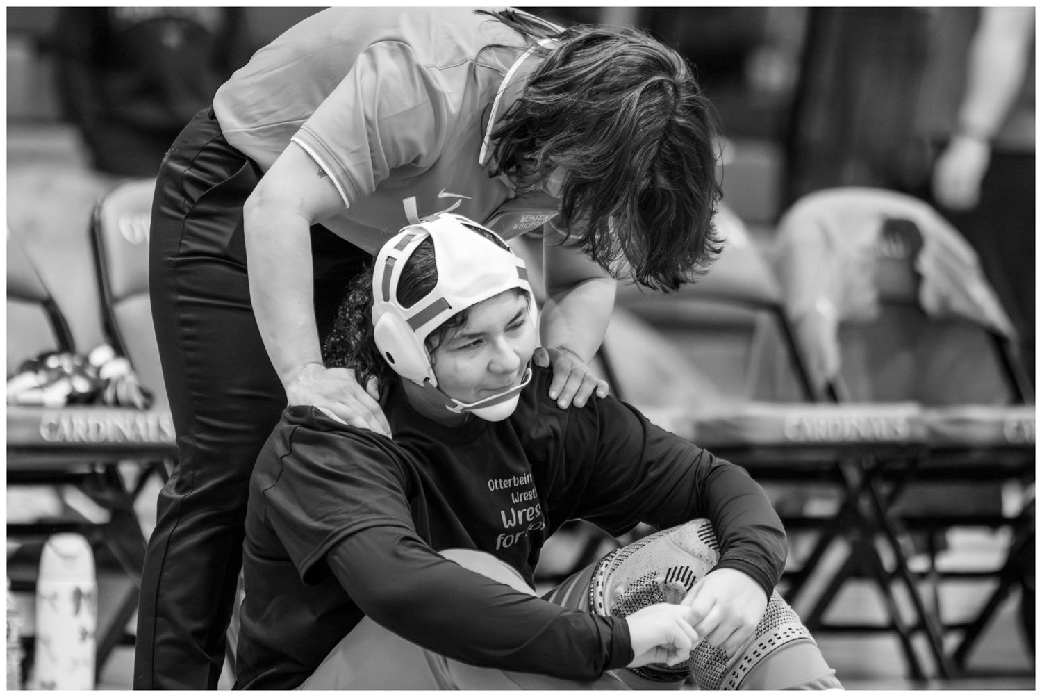 Black and white photo showing wrestling match preparation on sidelines.