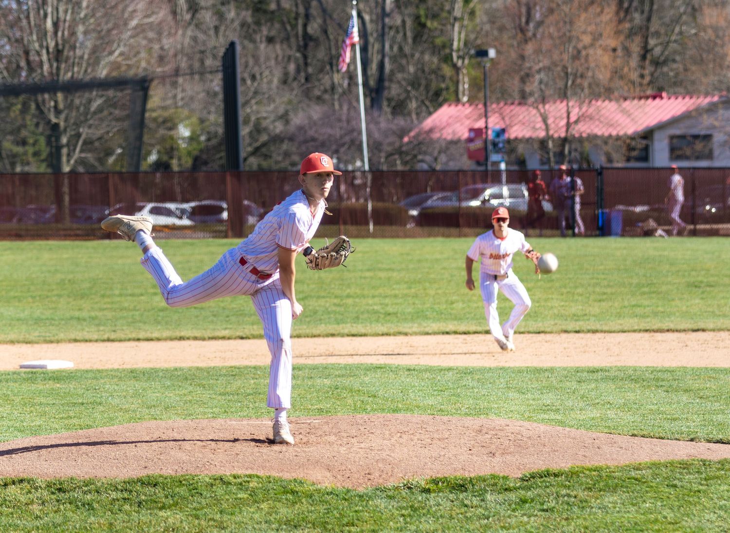 Baseball pitcher in mid-delivery motion on pitching mound during game.