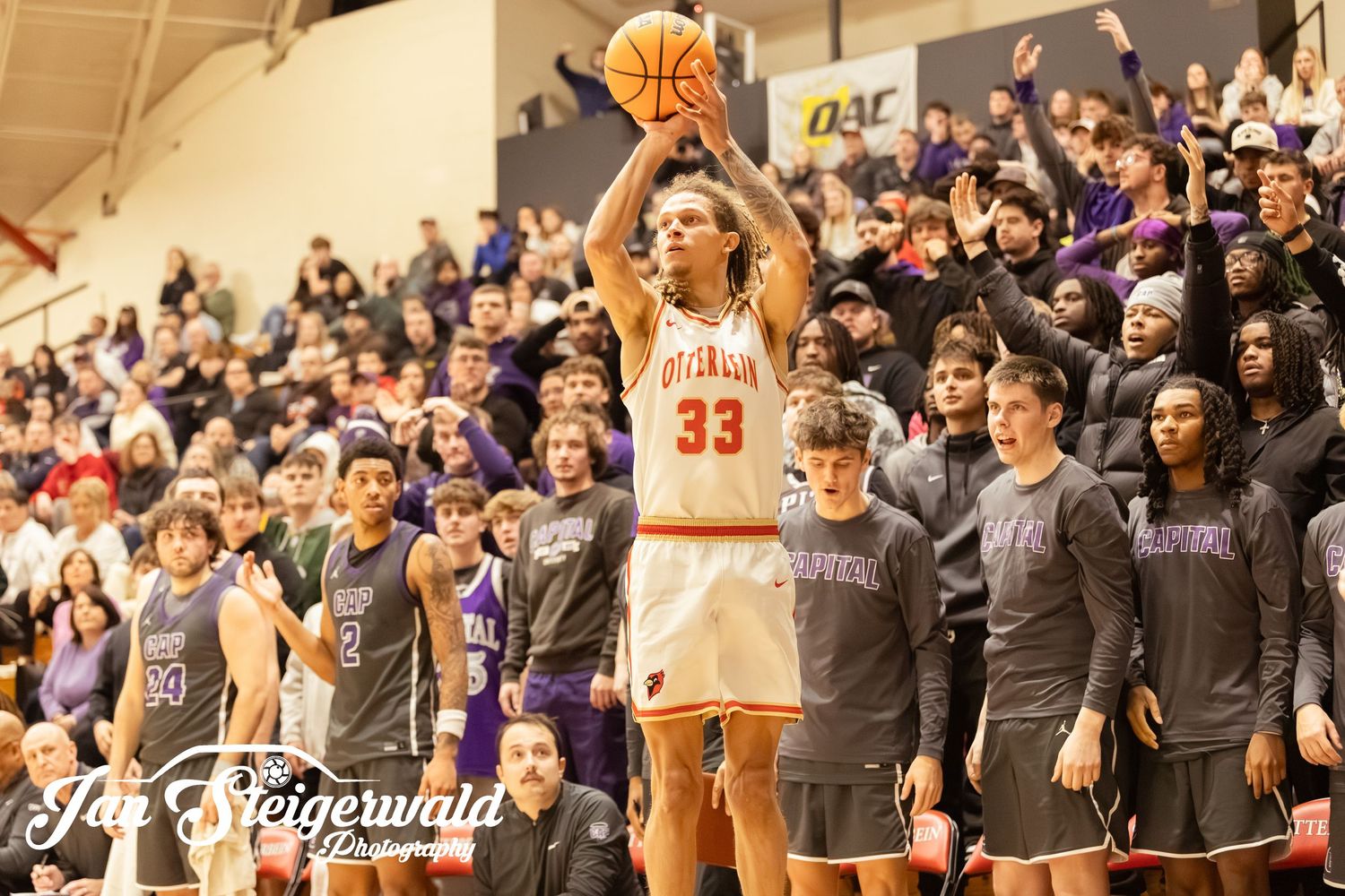 Basketball players and spectators gather in a gymnasium during an intense game moment.