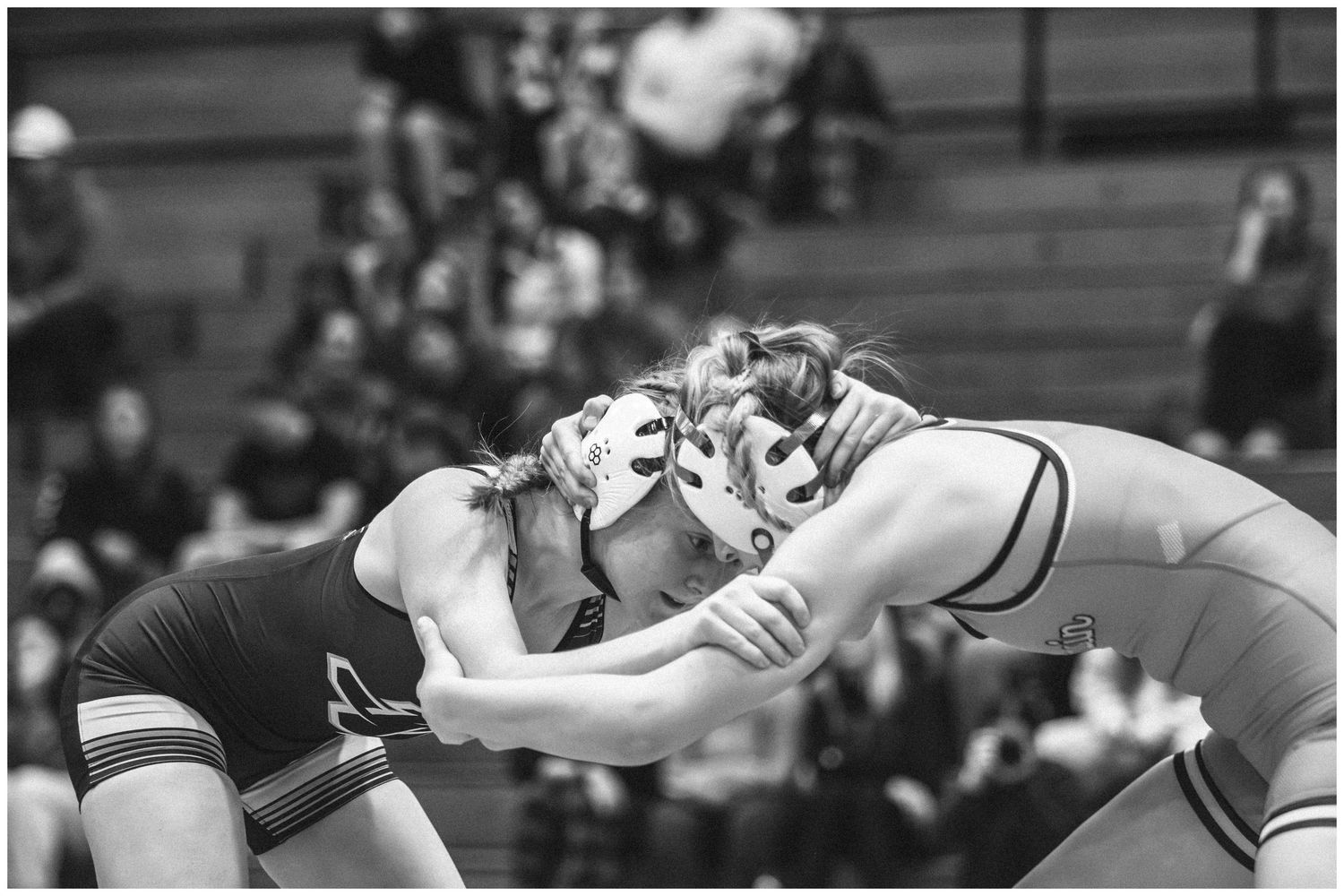 Black and white action shot of two wrestlers grappling during competitive match.