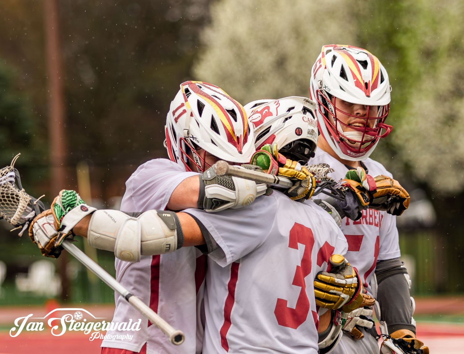 Lacrosse players engage in an intense match with players in white jerseys battling for possession of the ball.