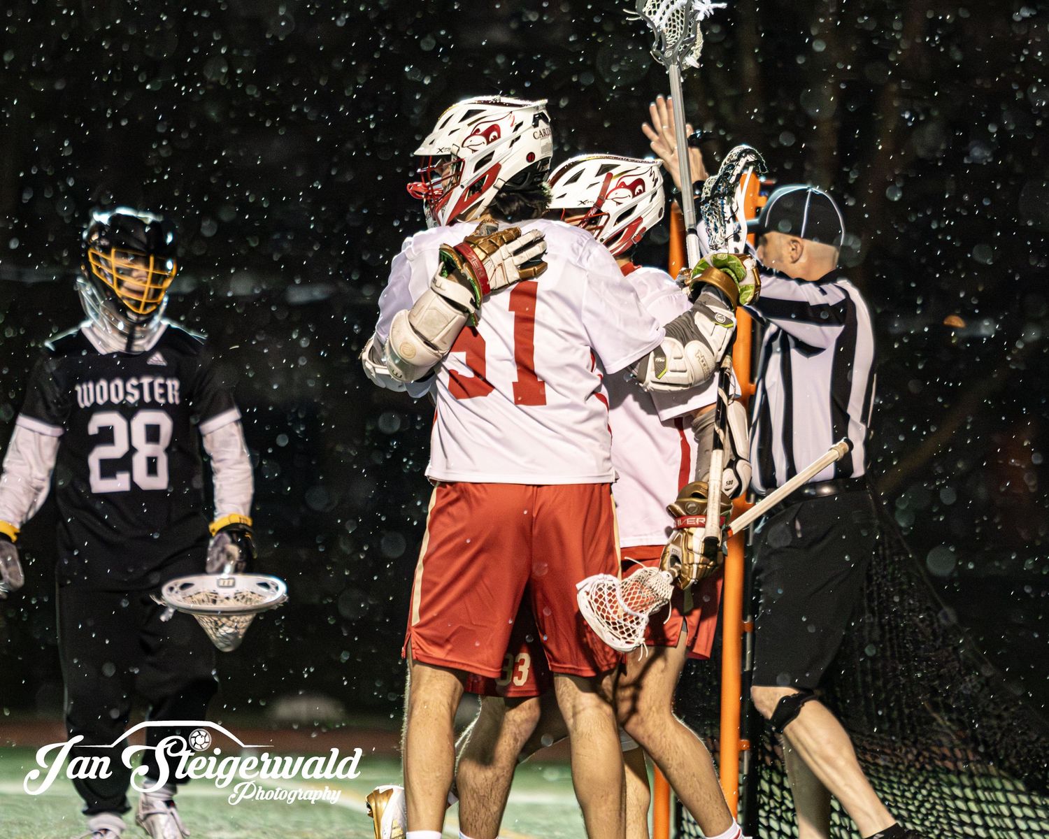 Professional lacrosse players in white and red uniforms compete for possession during an intense night game.