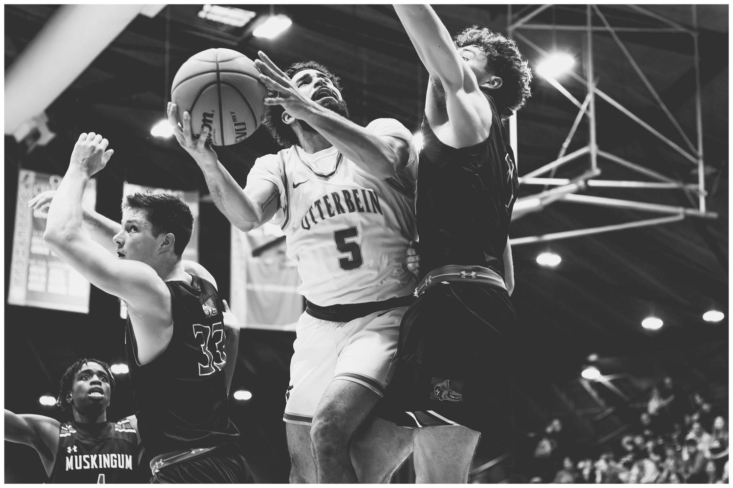 Vintage black and white photo of basketball game showing players battling for position.