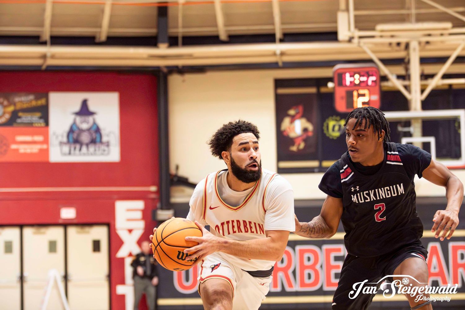 Basketball players compete for possession of the ball during an intense game on the court.