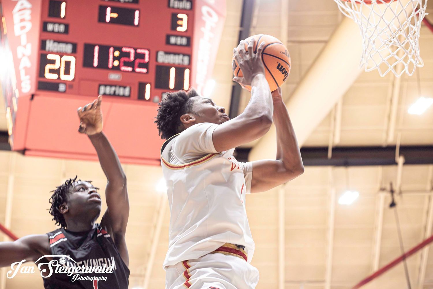 A basketball player rises up for a powerful slam dunk during an intense game.