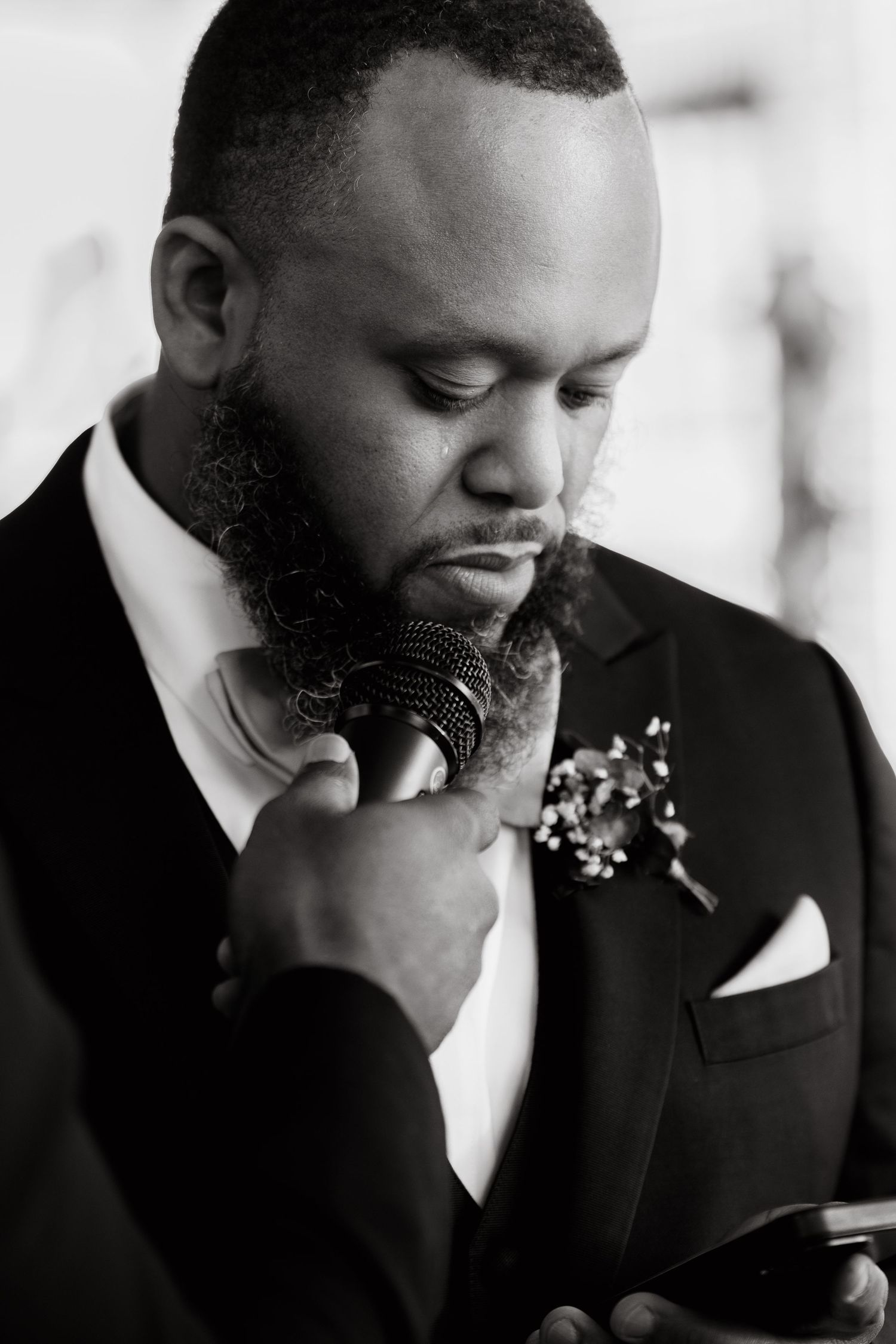 Black and white photo series showing emotional moments of a groom in a suit on his wedding day.