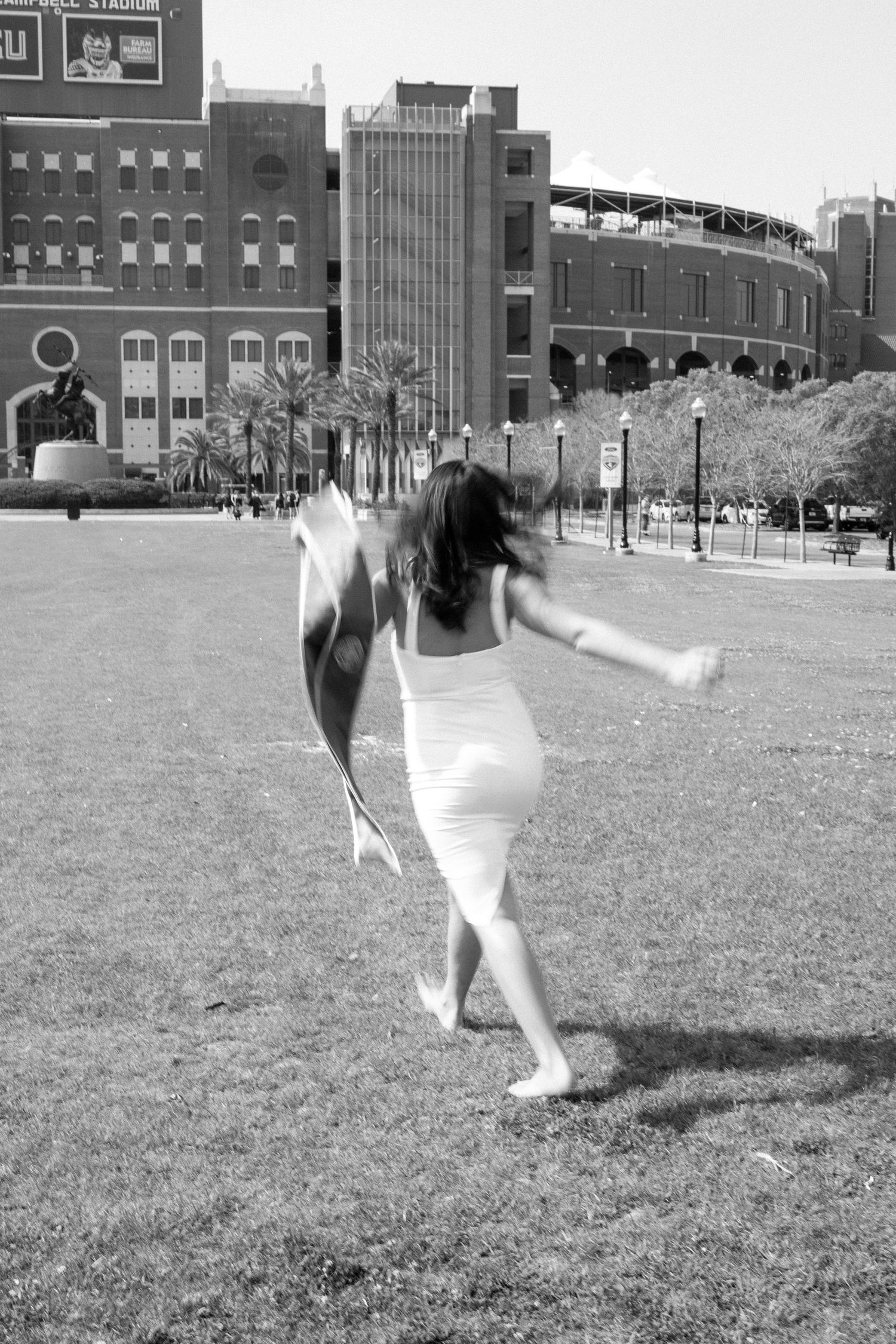 FSU Black and white photos showing a celebratory cartwheel on a grassy field near urban buildings.