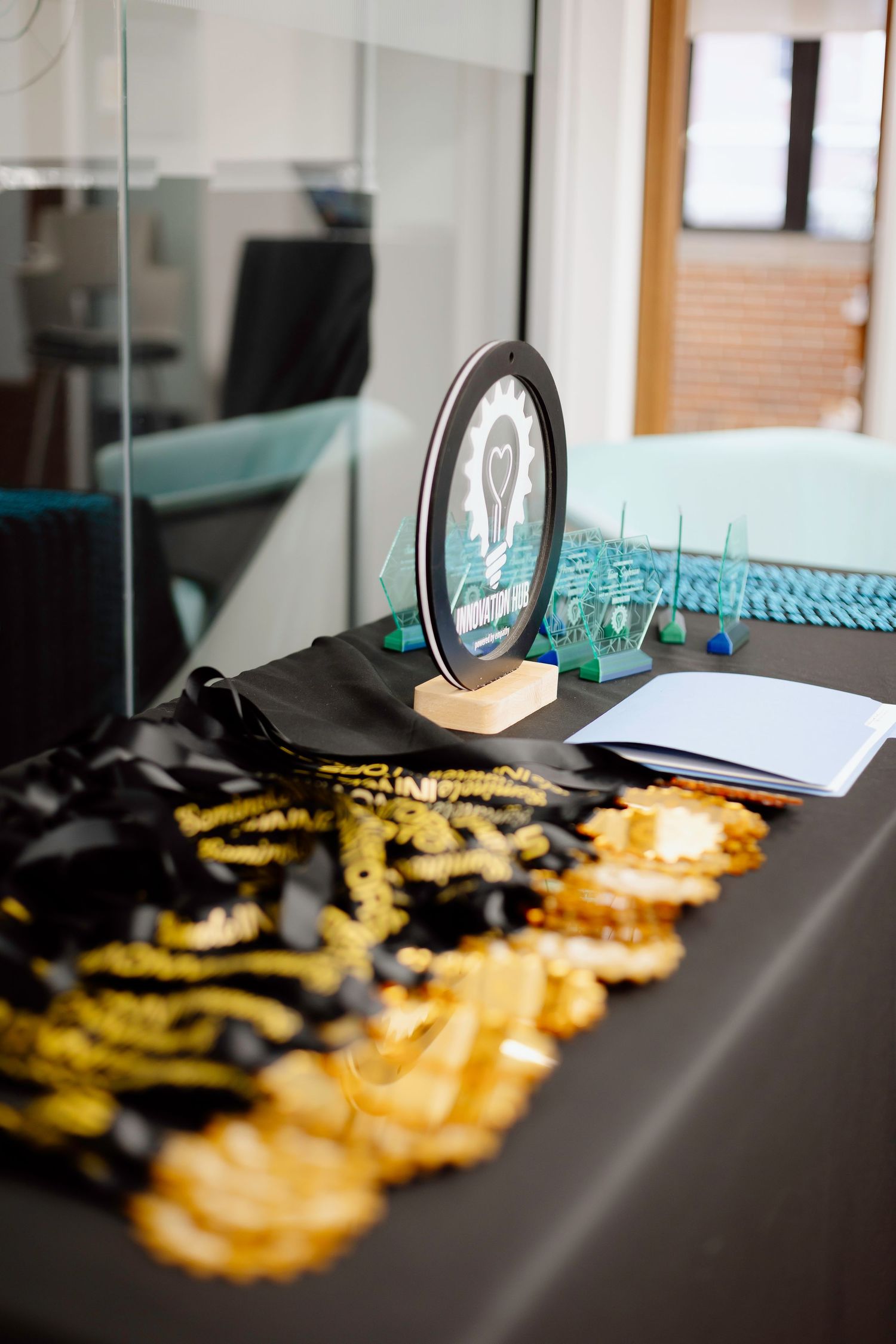 A collection of yellow and black lanyards laid out on a dark table with a display stand and papers.