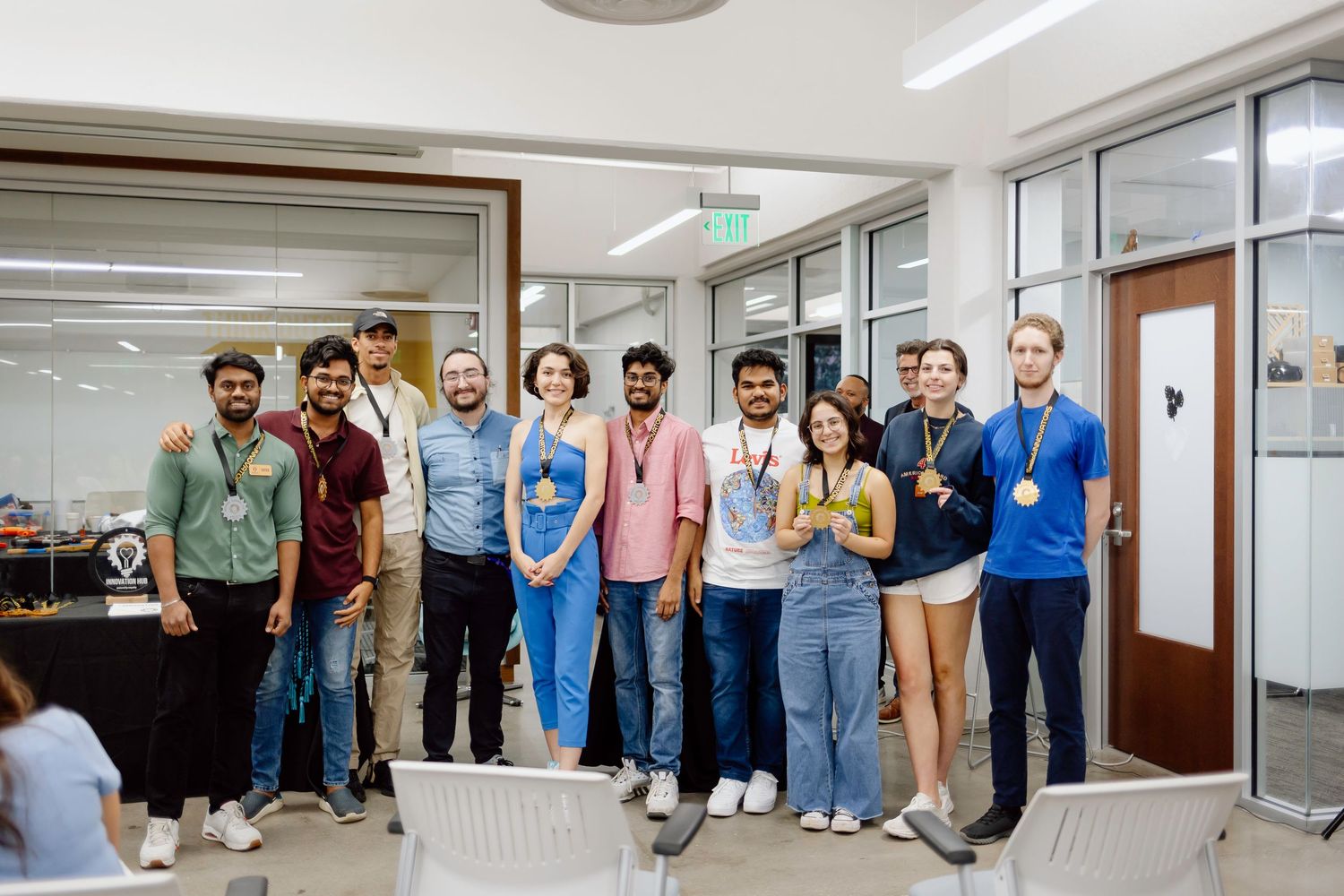 Group of professionals gathered in a modern office hallway for a corporate photo opportunity.