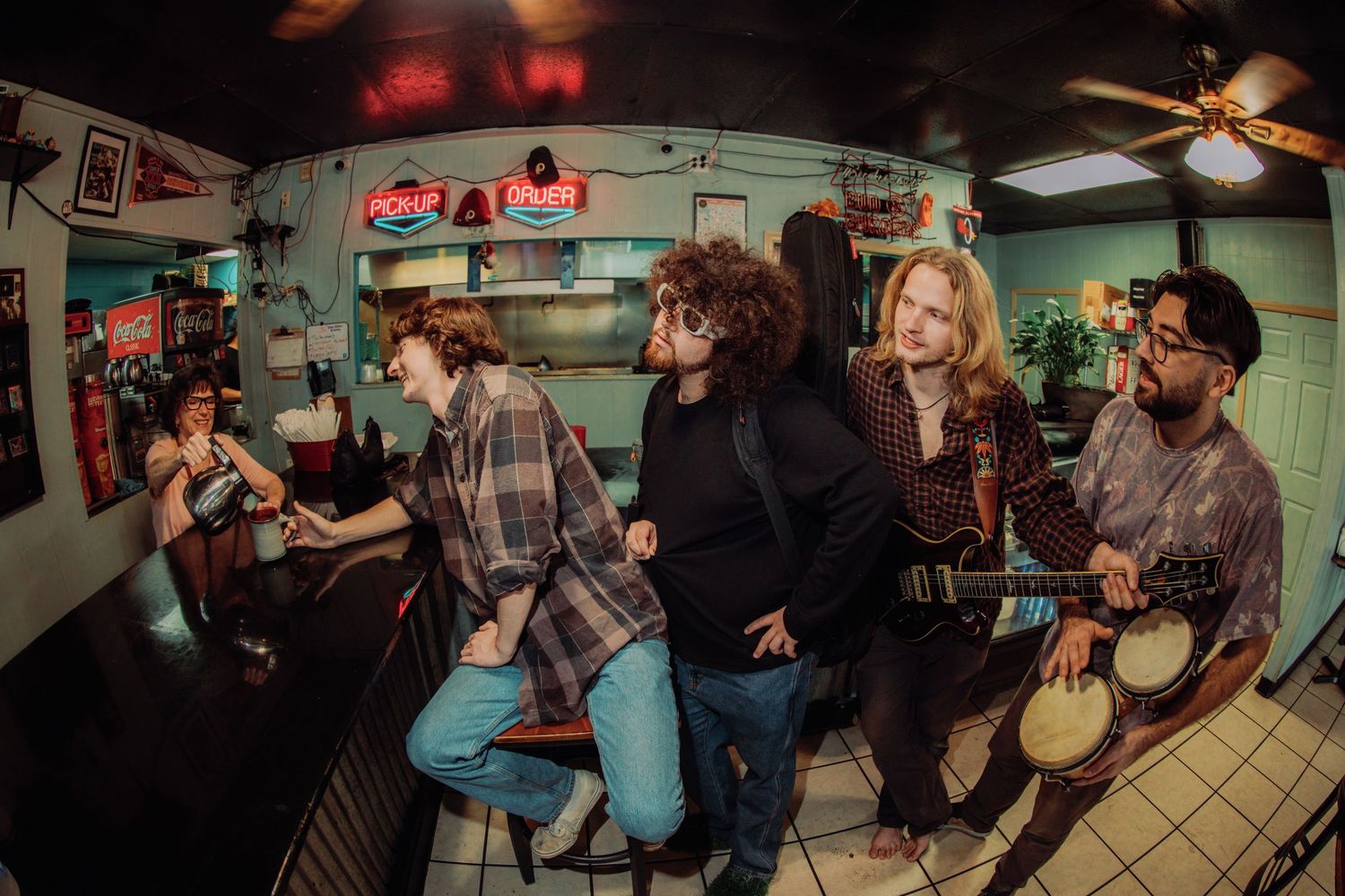 Musicians perform together in a dimly lit venue creating an energetic live music atmosphere.
