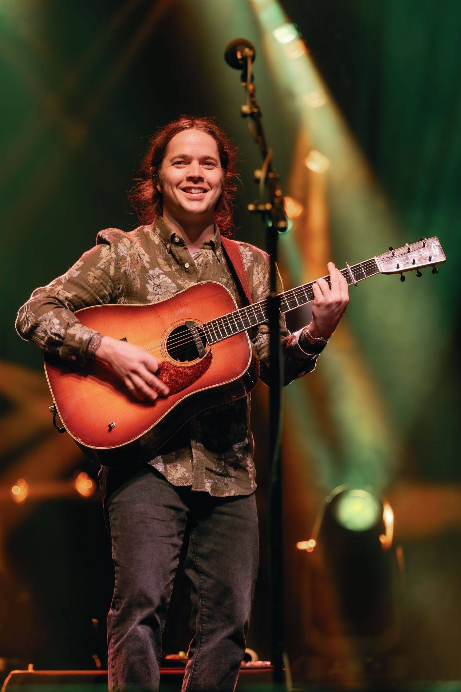 A musician performs on stage with an acoustic guitar under warm stage lighting in a series of sequential performance shots.