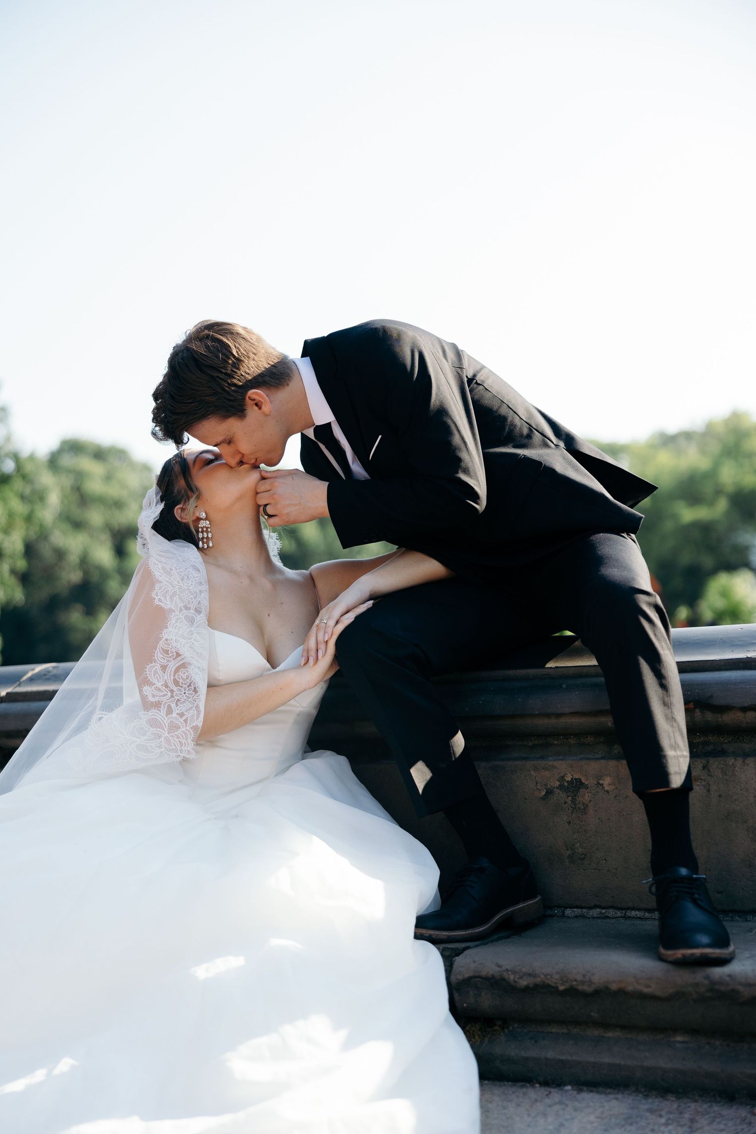 A romantic wedding couple shares tender kisses in a sequence of photos captured outdoors on a sunny day.