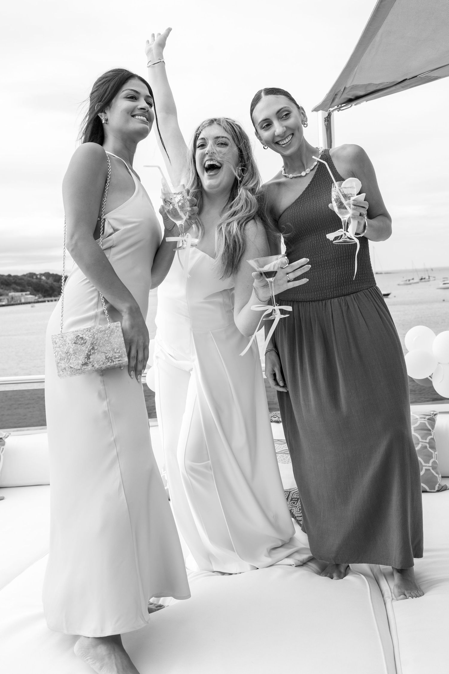 Engagement celebration on a boat deck with cocktail glasses.