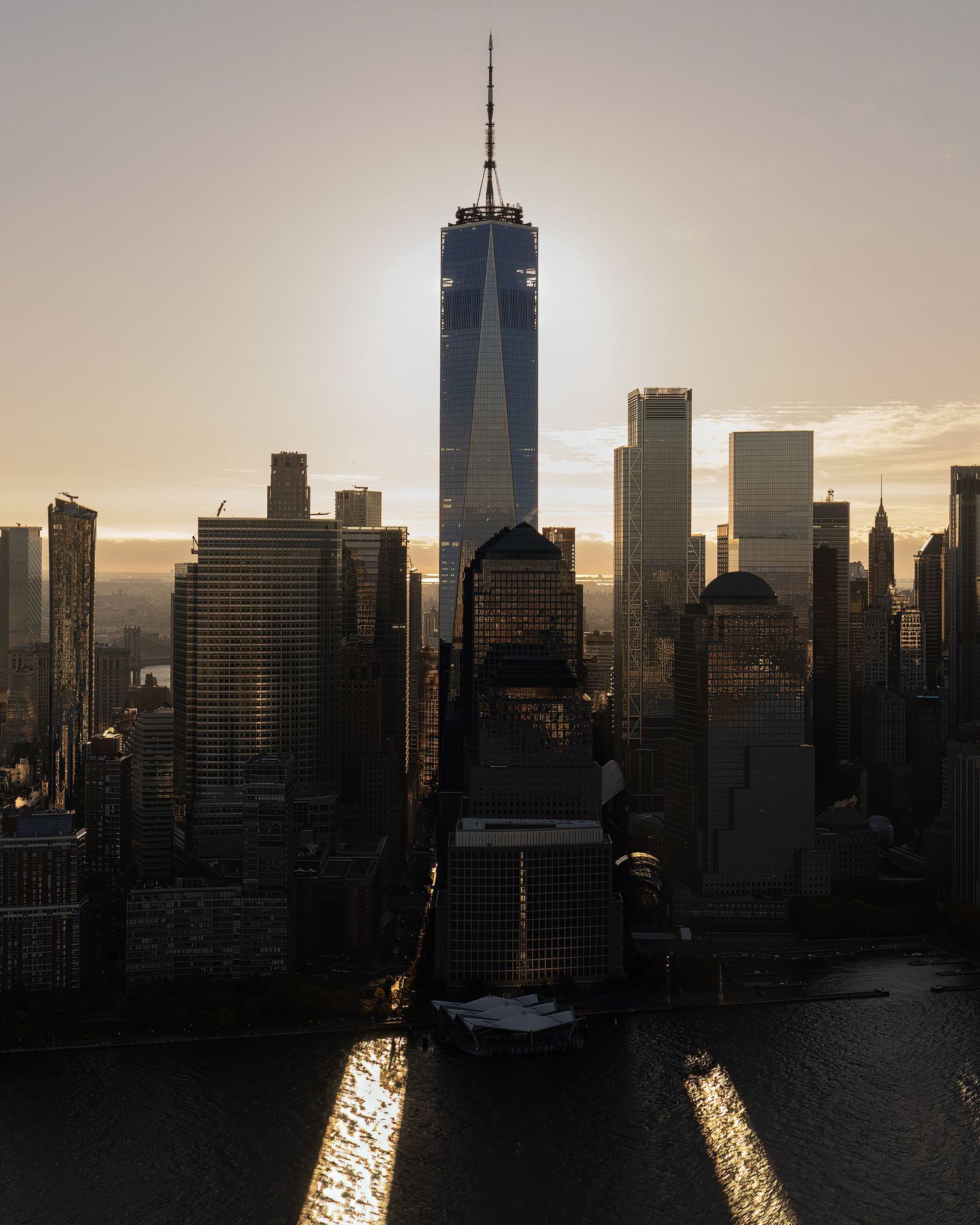 New York City skyline silhouetted against a moody sky as darkness falls over Manhattan.