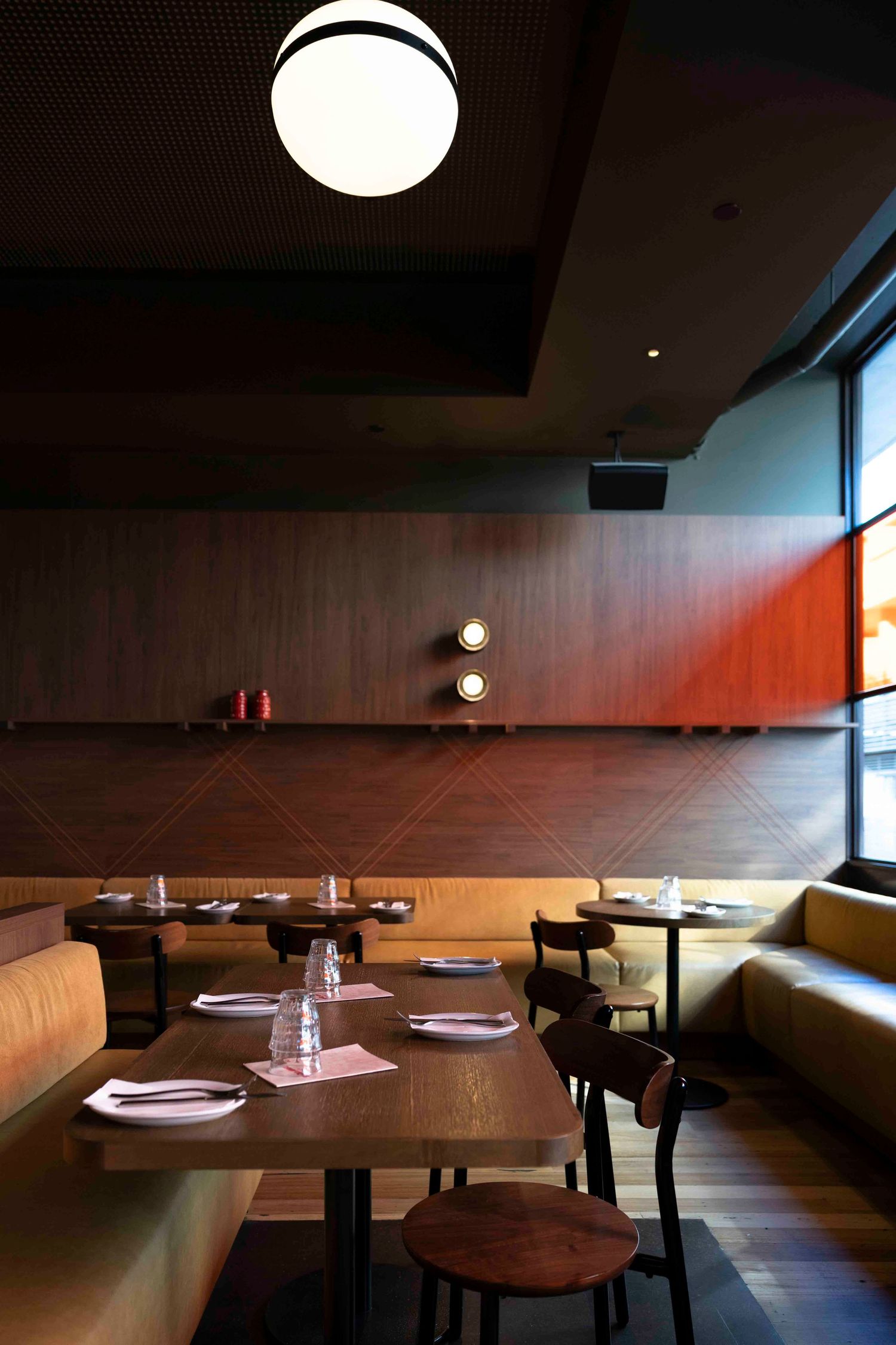 Dining room with leather banquettes and warm light at Studio Amaro, Melbourne