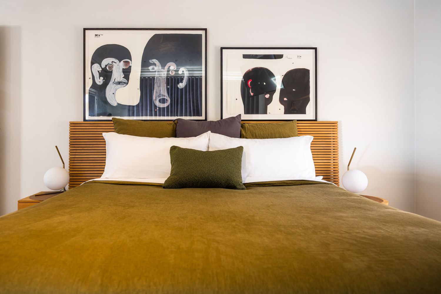 Bed with olive linen, a timber bedhead and bold framed artwork in Suite 4 at Hotel Ernest, Bendigo