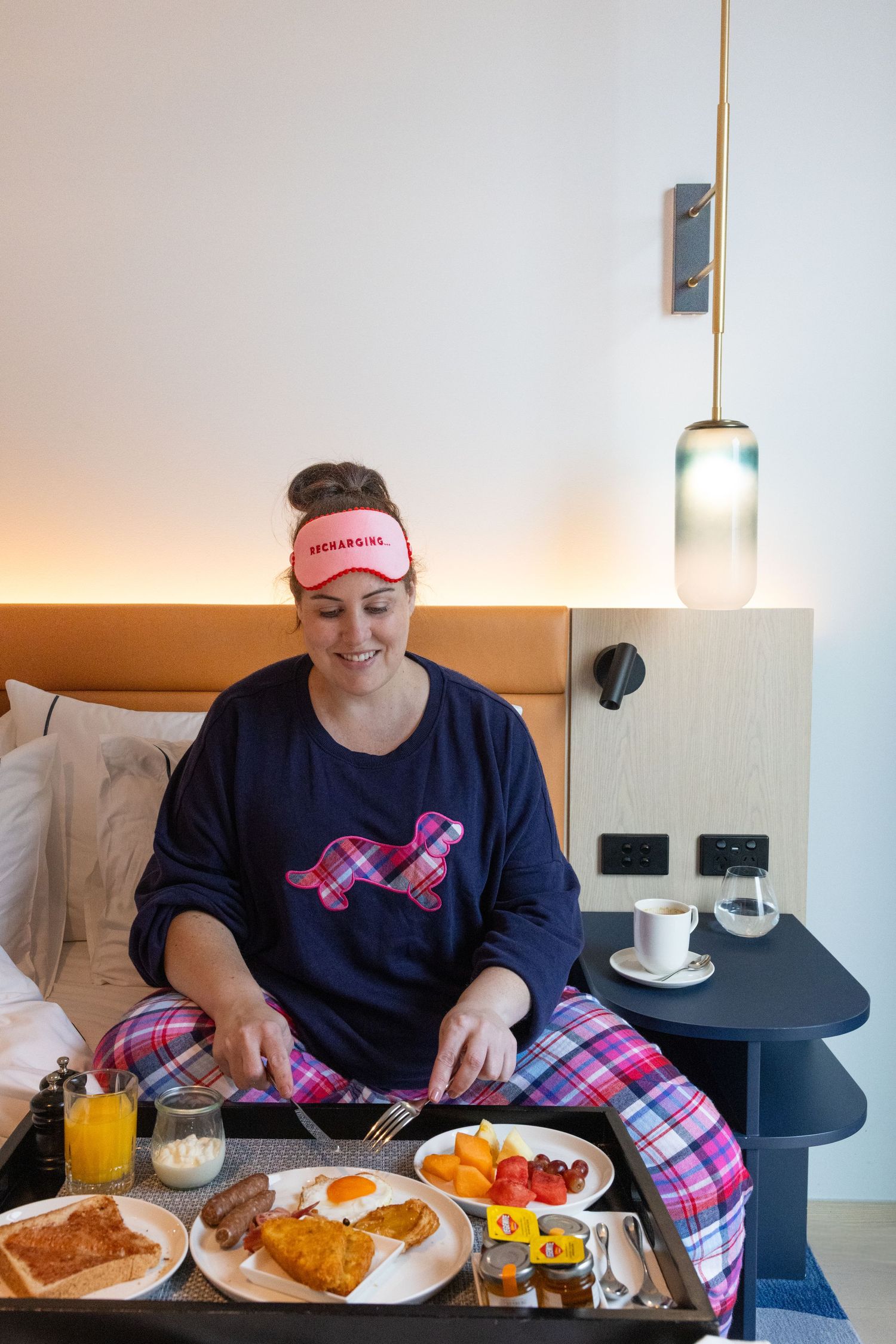 Guest enjoying breakfast in bed at Lanson Place Parliament Gardens, Melbourne