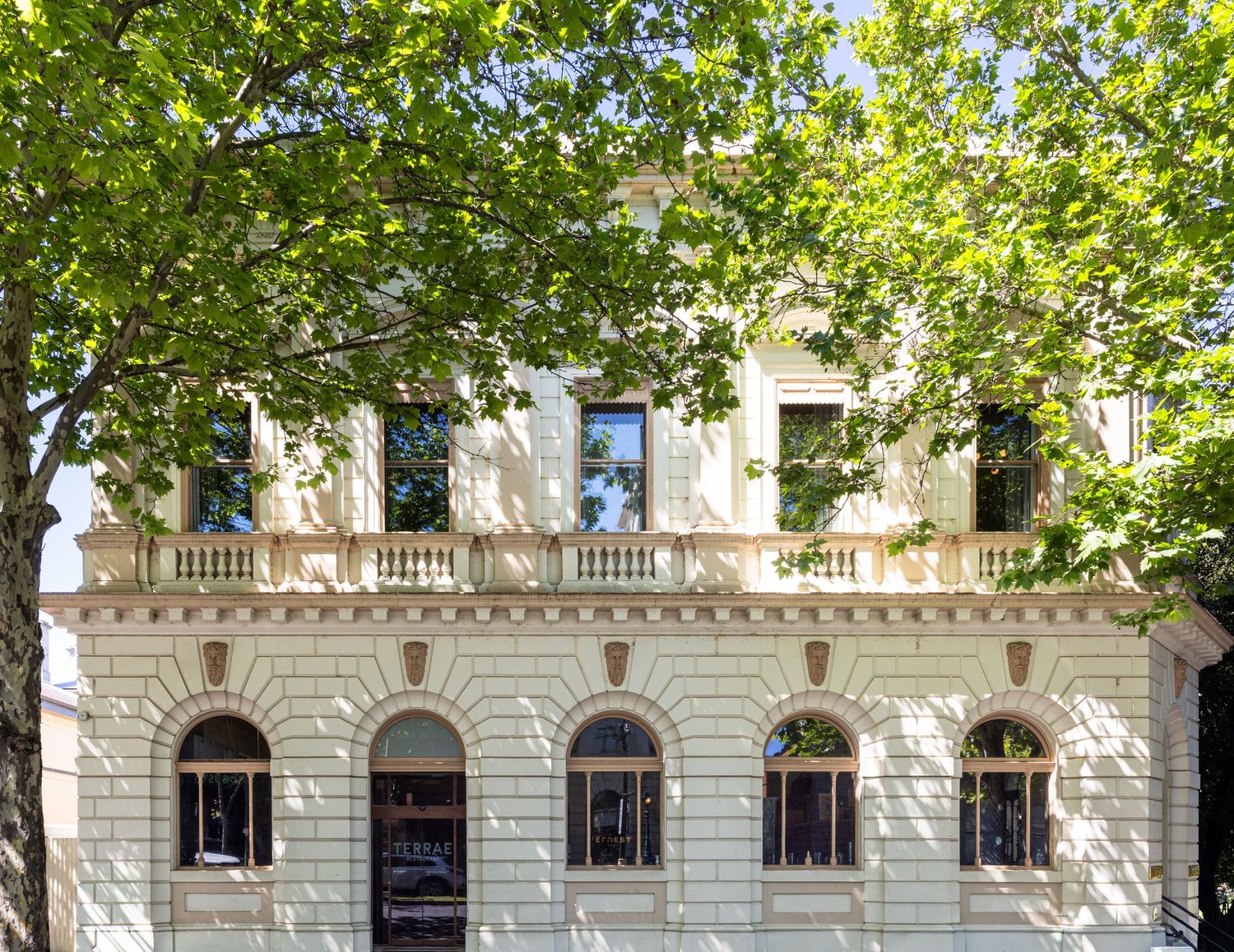 Heritage facade of Hotel Ernest and Terrae restaurant framed by green trees, Bendigo