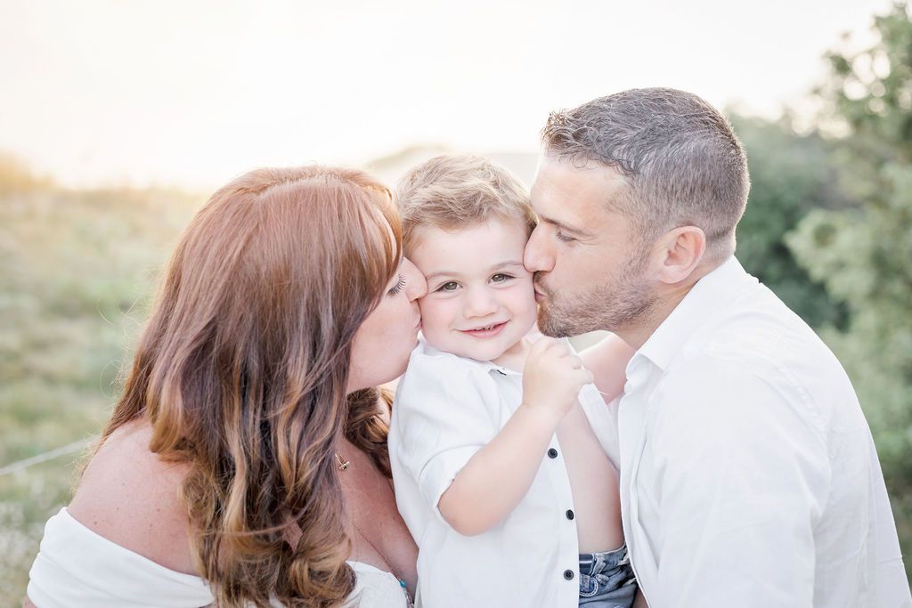 Sweet family moment captured on a sandy beach path at golden hour.