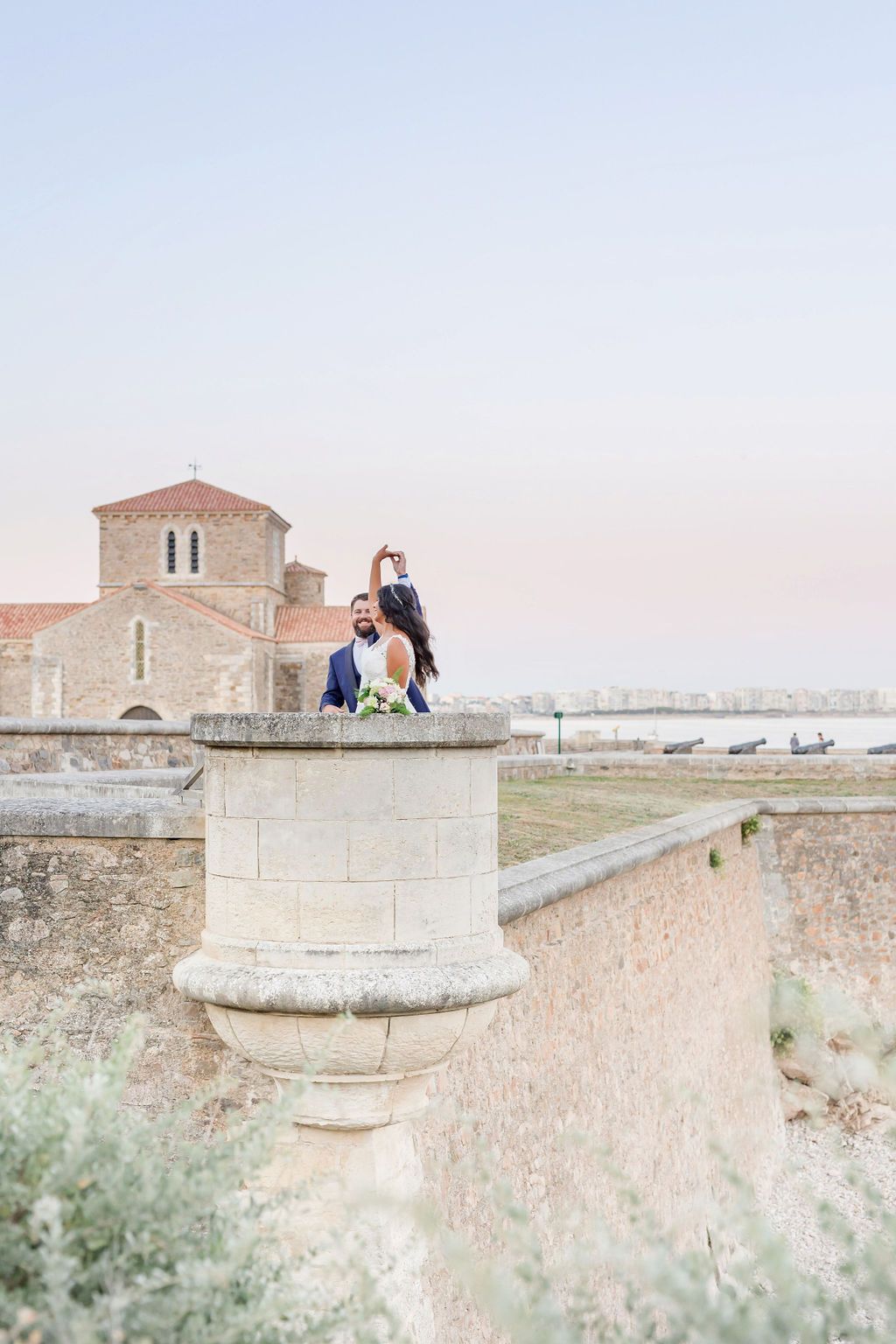 Sunset photoshoot on ancient fortress walls overlooking Mediterranean waters.