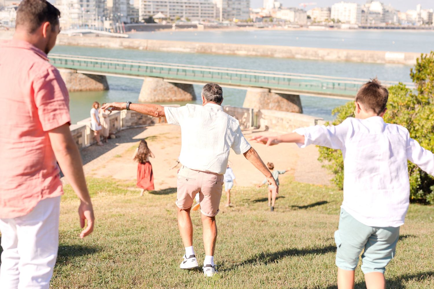 Candid family moments captured during outdoor photoshoot near waterfront.