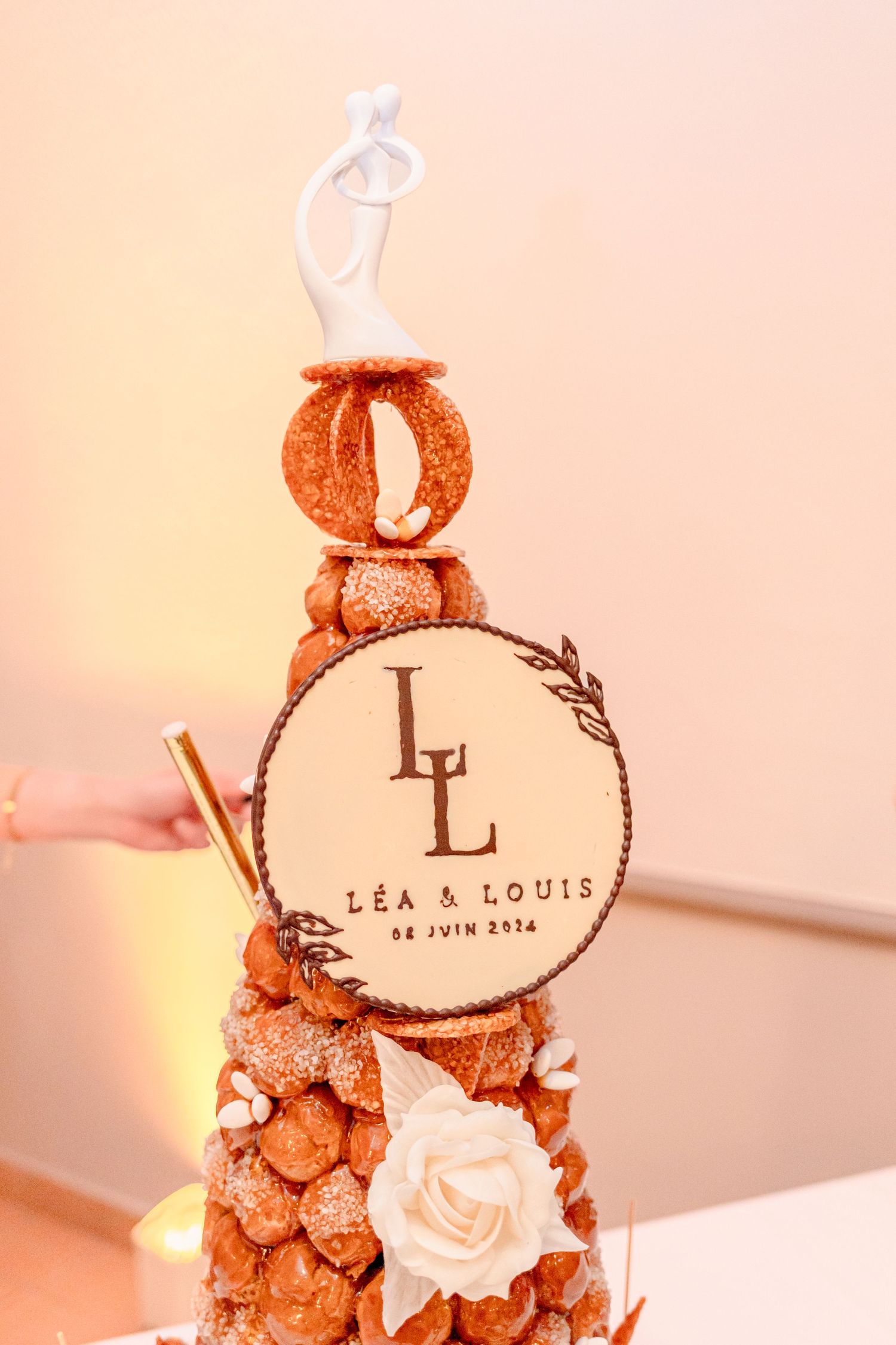 Elegant wedding cake decorated with copper details and white floral accents.