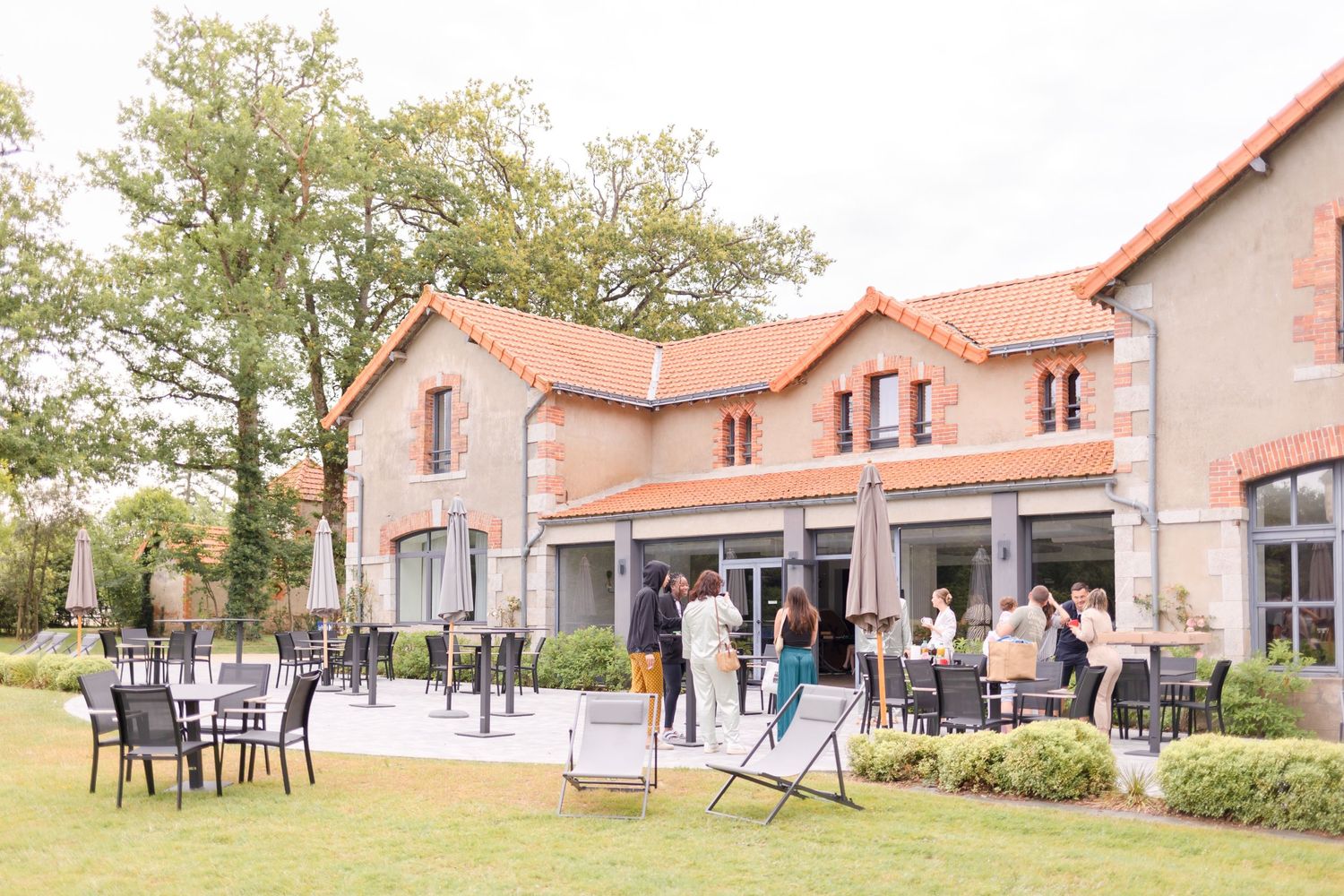 Elegant venue with outdoor seating area and terracotta-colored building facade.