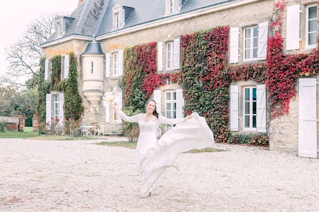 Romantic movement of white fabric against stone mansion with autumn-colored ivy.