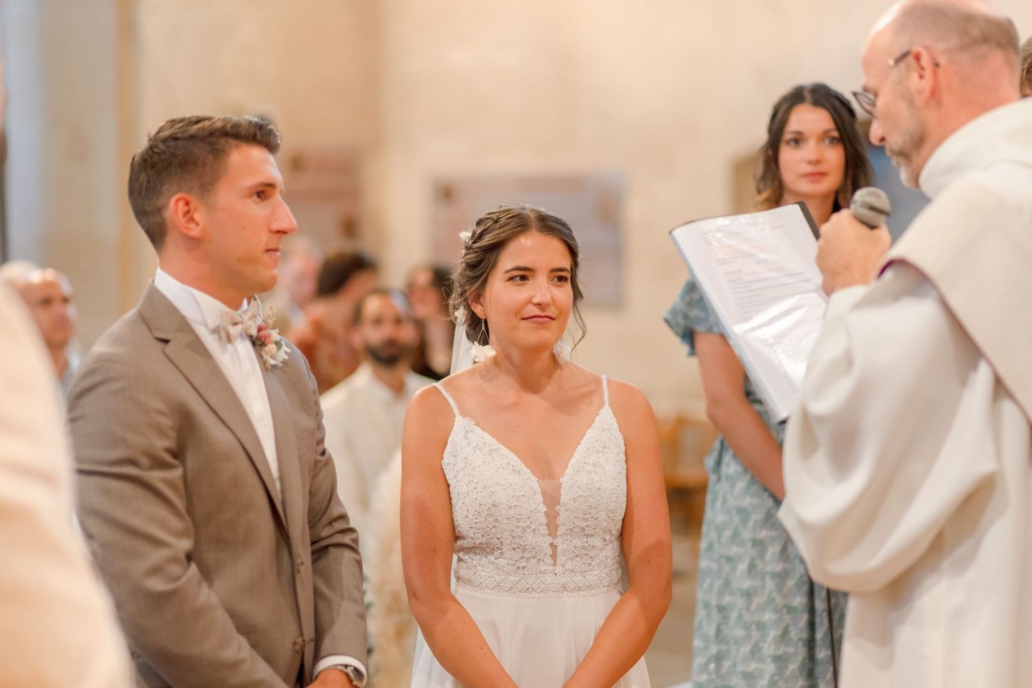 Close-up of wedding ceremony with warm lighting in church setting.