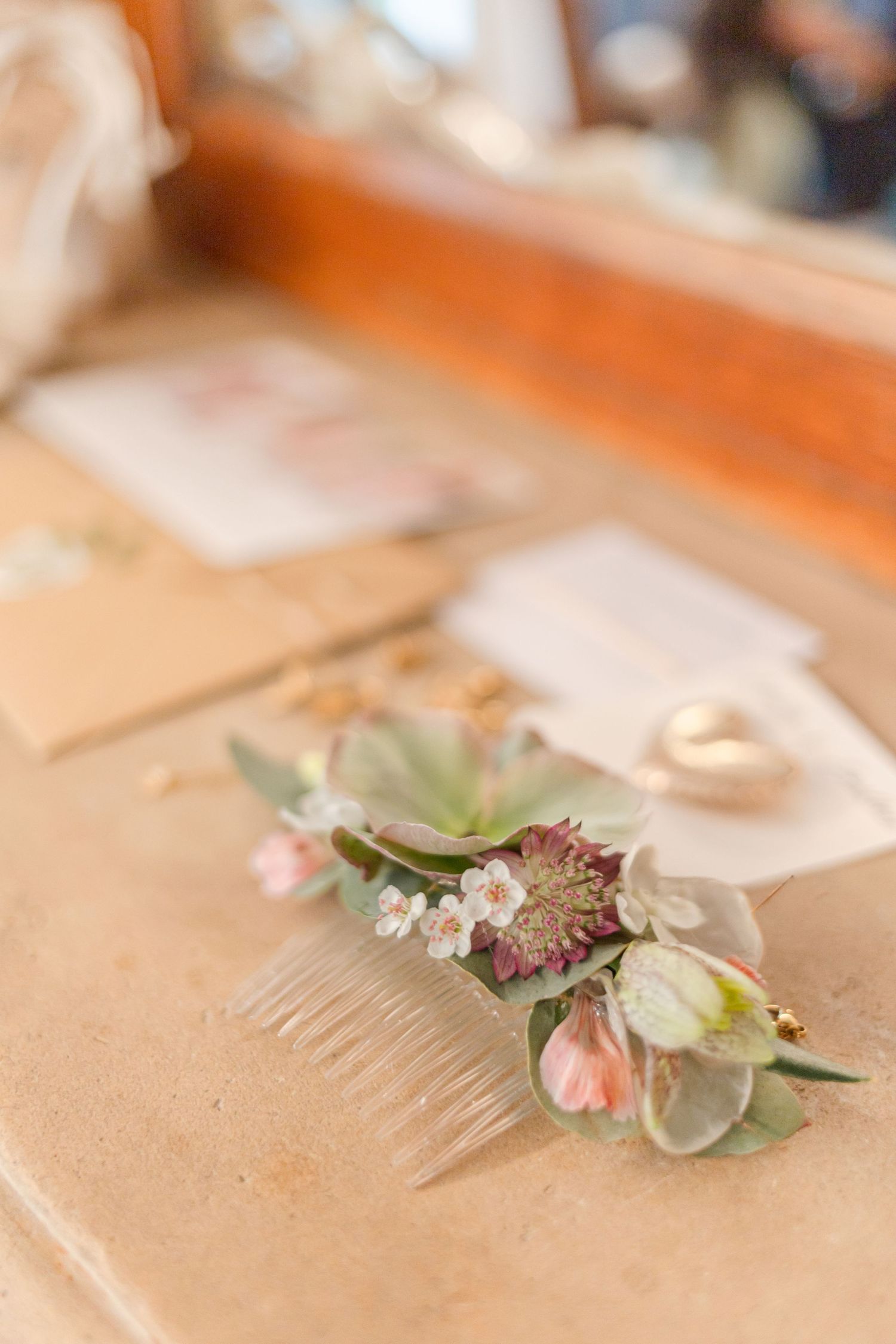 Delicate floral hair accessory with pink and white flowers on beige surface.