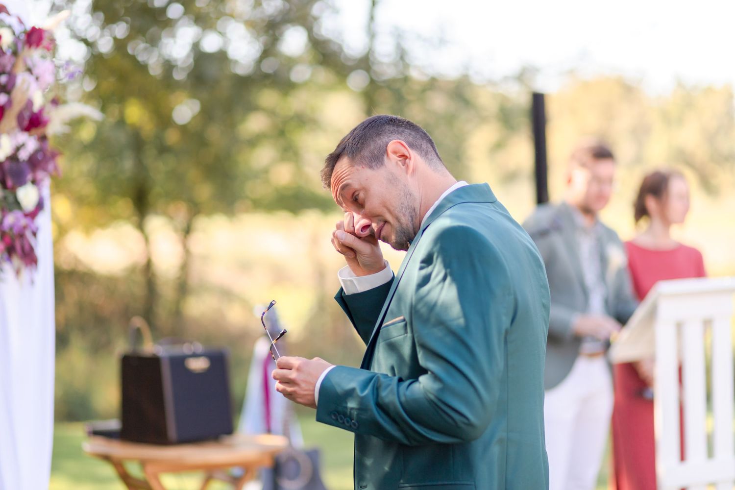 Speaker delivers emotional speech during outdoor wedding ceremony.